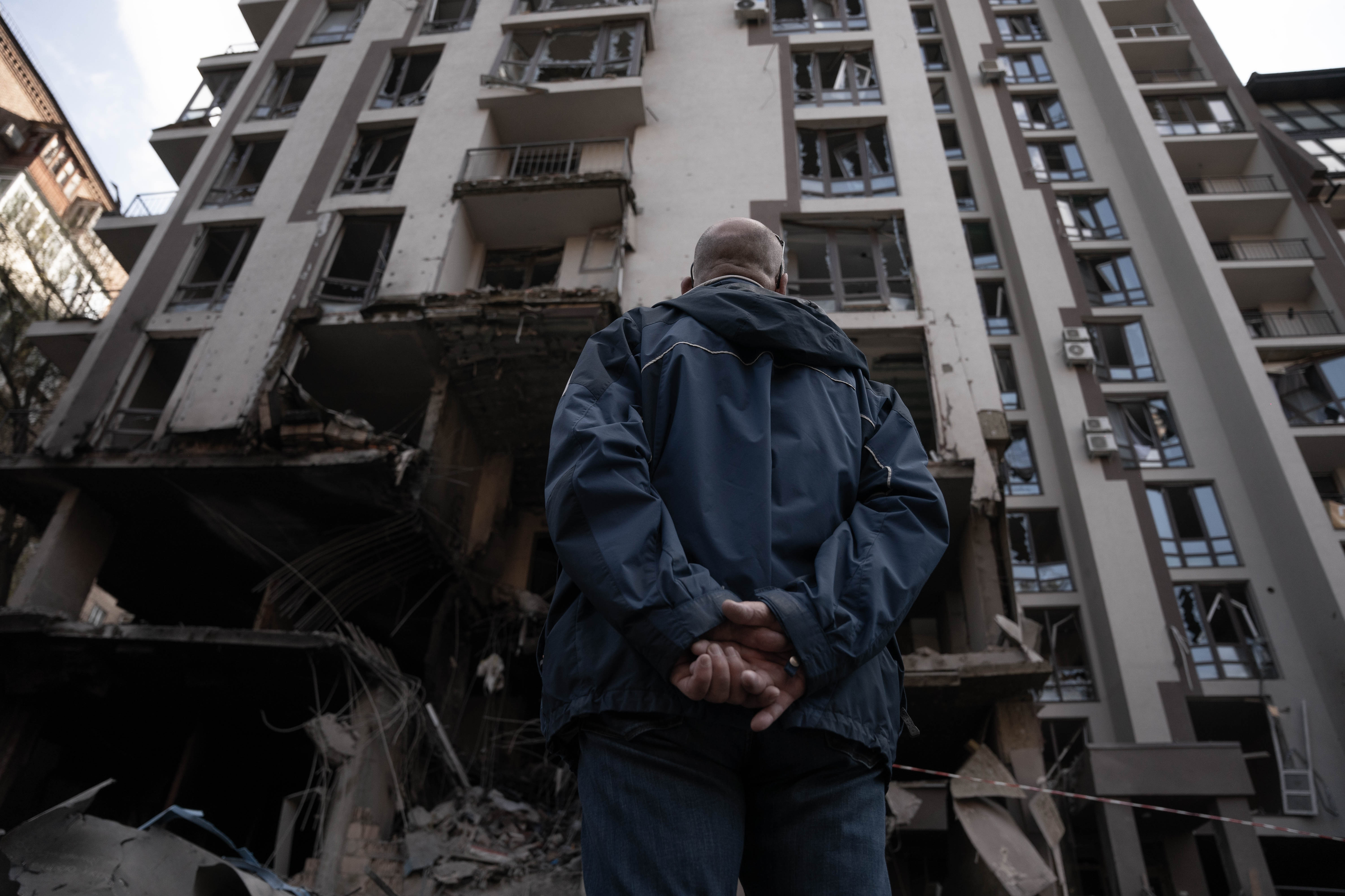 Un vecino del distrito de Shevchenkivskyi, se detiene para observar los destrozos ocasionados en el edificio.