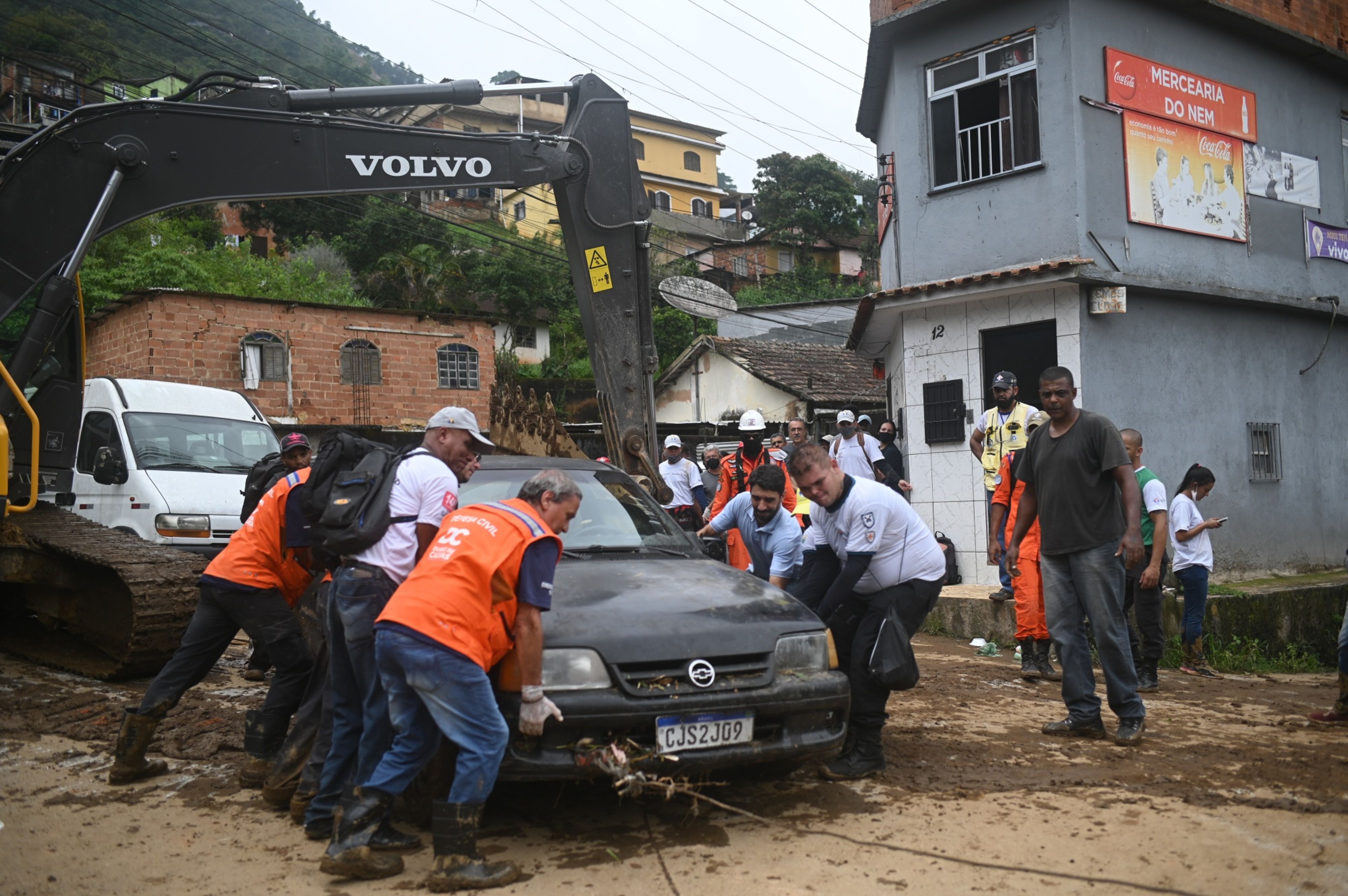 Los residentes y los rescatistas retiran un automóvil que fue arrastrado por una inundación  (Bloomberg)