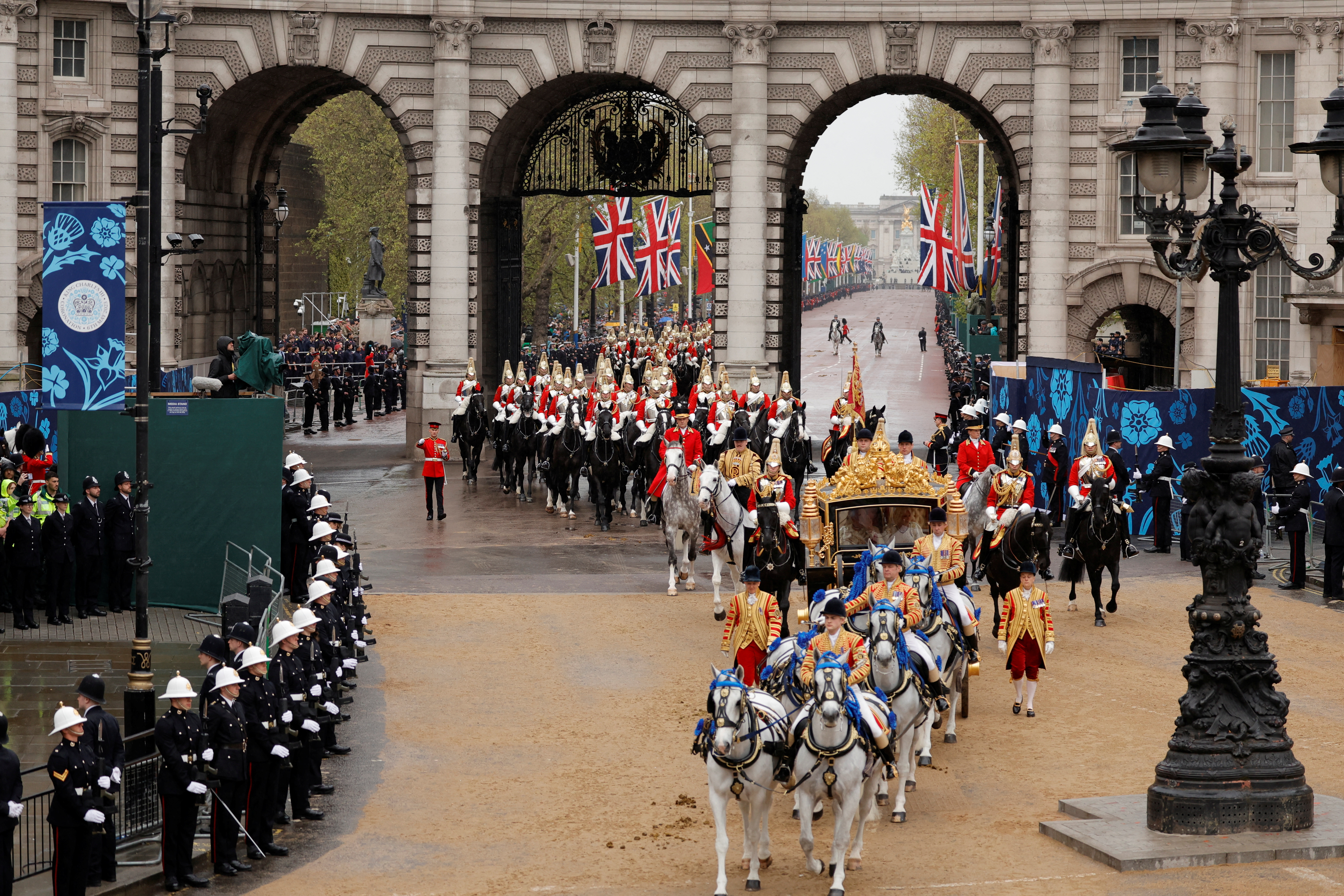 El rey Carlos de Inglaterra y la reina Camilla viajan en el autobús de Estado del Jubileo de Diamante pasando por el Arco del Almirantazgo desde el Palacio de Buckingham hasta la Abadía de Westminster para su ceremonia de coronación a lo largo de Whitehall en Londres, Gran Bretaña, el 6 de mayo de 2023. REUTERS/Piroschka van de Wouw/Pool