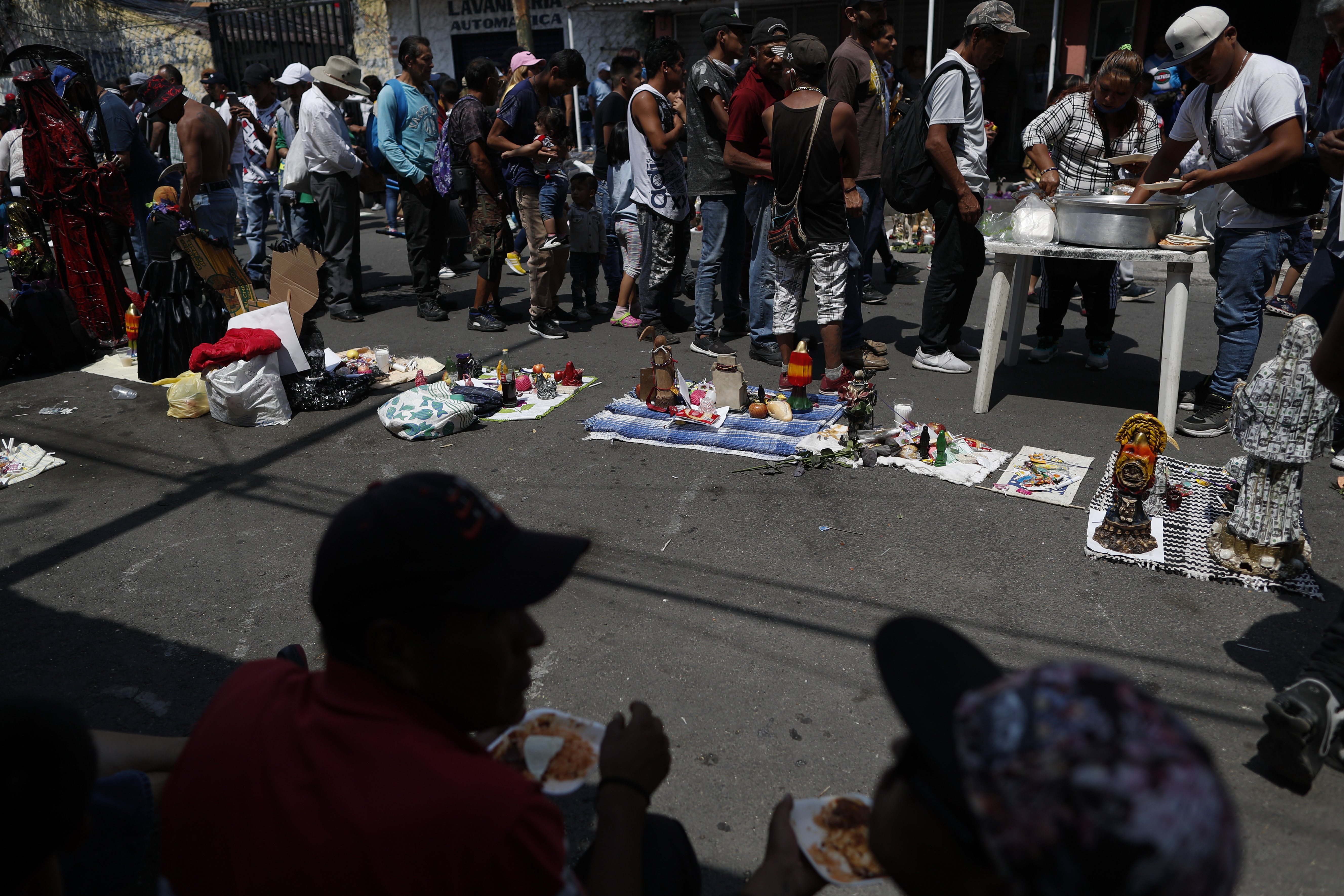 Los devotos de la Santa Muerte hacen cola para recibir un almuerzo donado, frente a un altar en el barrio de Tepito de la Ciudad de México, el lunes 1 de junio de 2020. (Foto: AP / Rebecca Blackwell)