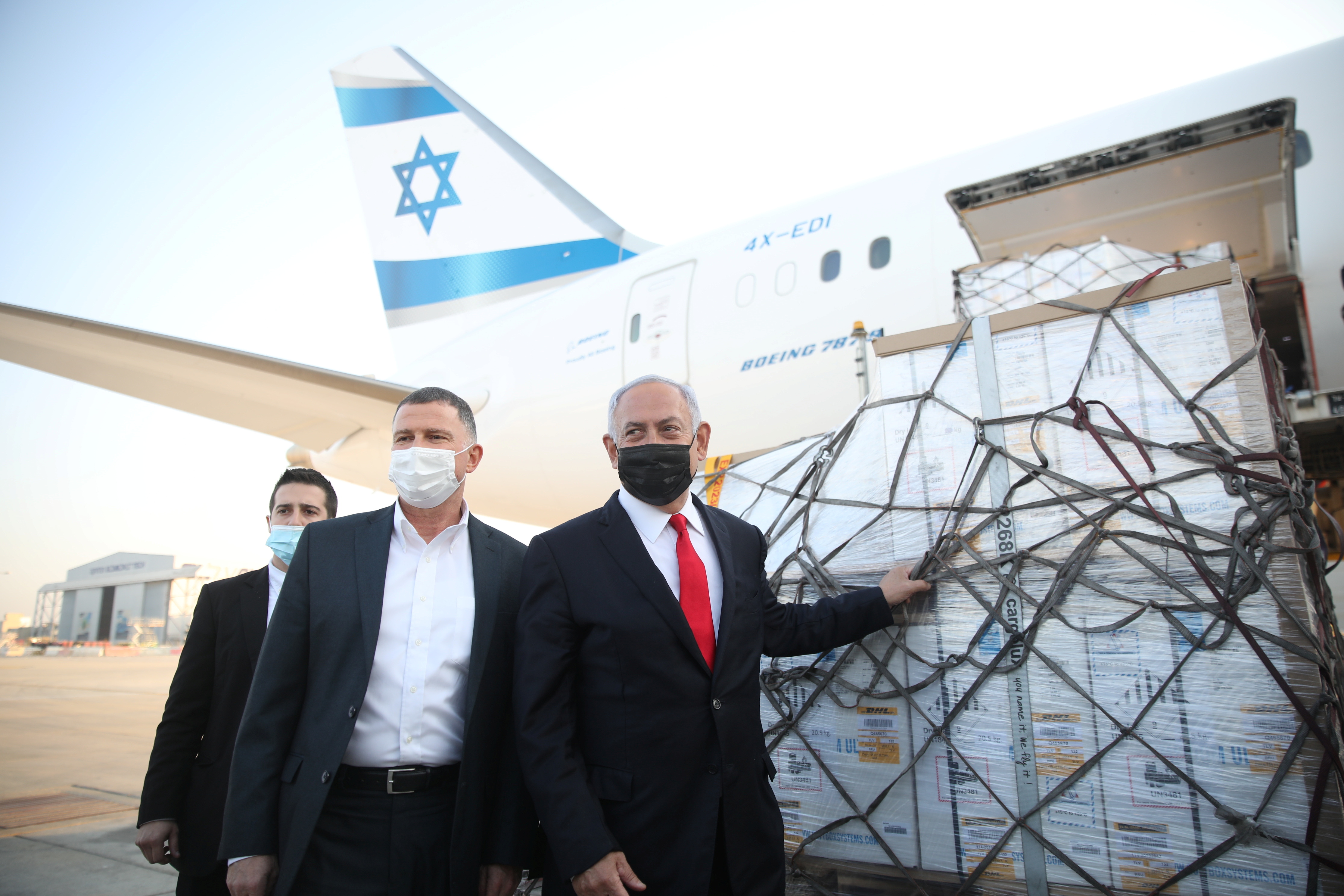 El Primer Ministro de Israel Benjamin Netanyahu y el Ministro de Salud Yuli Edelstein asisten a la llegada de un avión con un cargamento de vacunas contra la enfermedad coronavirus Pfizer-BioNTech (COVID-19), al aeropuerto Ben Gurion, cerca de la ciudad de Lod, Israel, el 10 de enero de 2021. (REUTERS)
