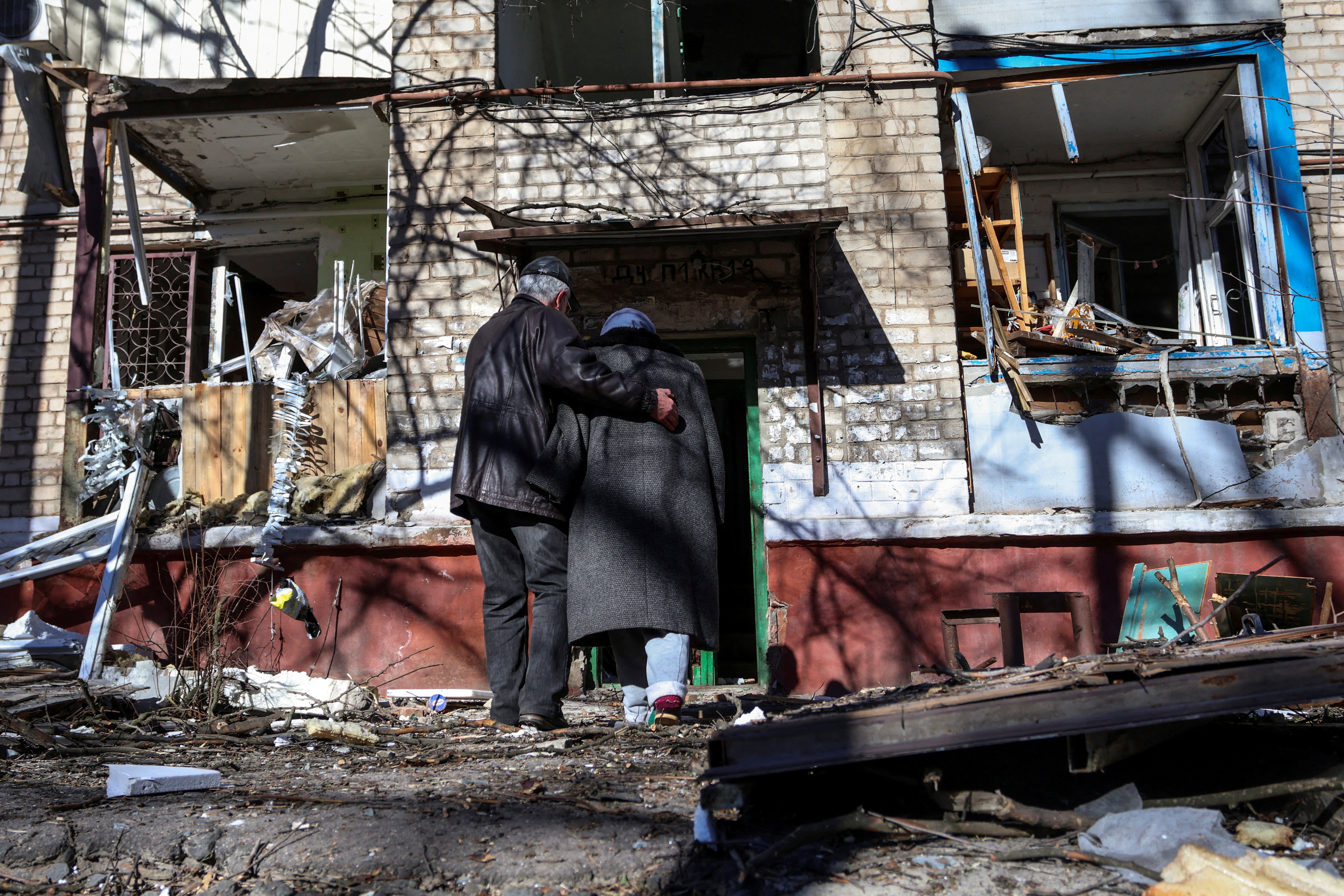Una pareja ingresa a un edificio residencial dañado por el ataque con misiles rusos en Kramatorsk (REUTERS/Yan Dorbronosov)