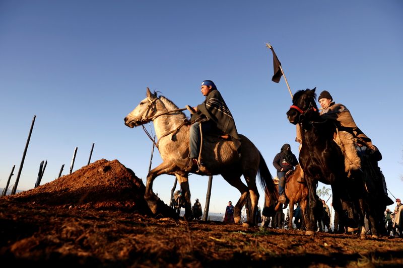 Weichafes (guerreros mapuches) montan sus caballos alrededor de la tumba de un compañero en la Araucanía, Chile (Foto: Reuters)