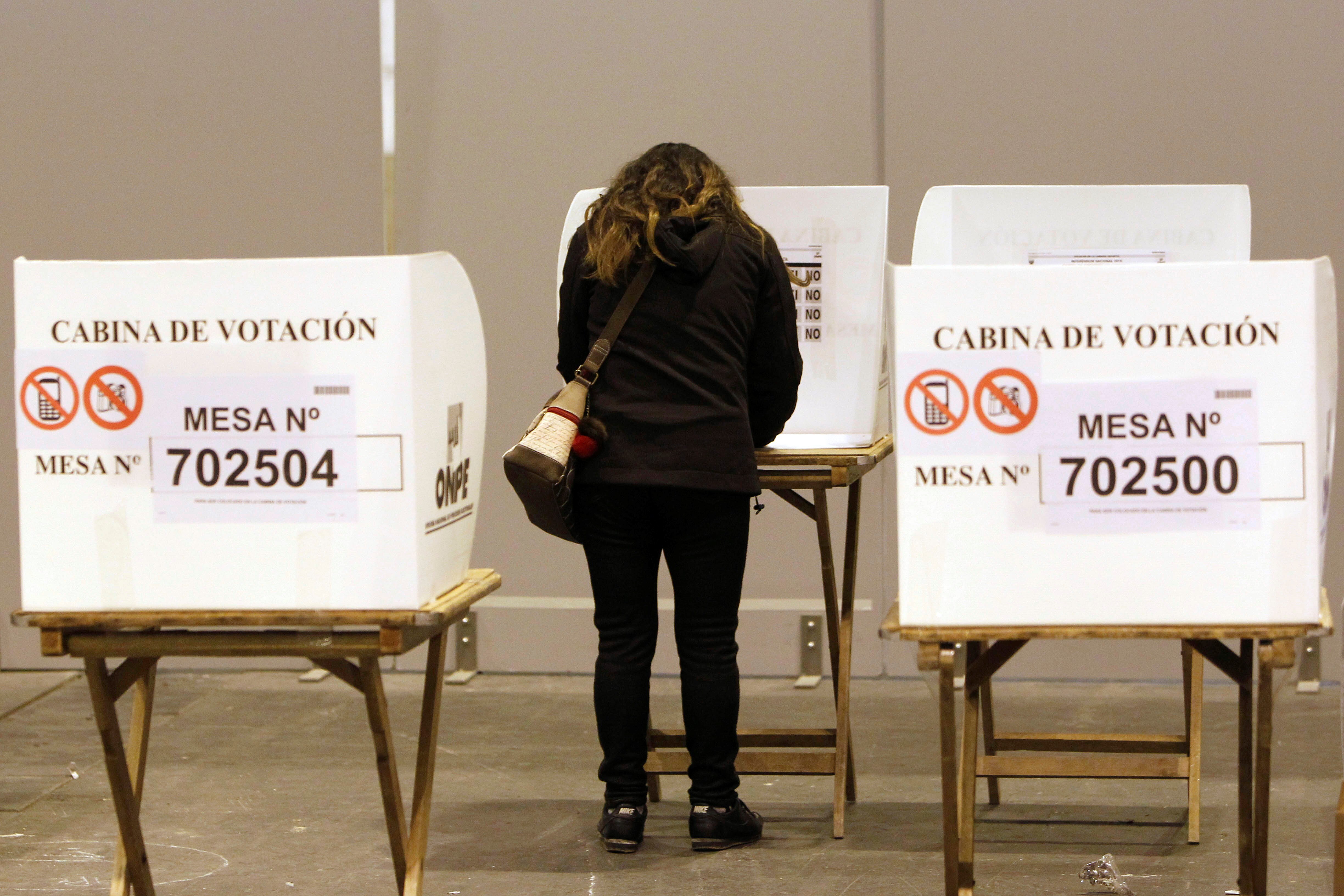 Una ciudadana peruana elige la papeleta de voto en el recinto de Ifema de Madrid. EFE/Paolo Aguilar/Archivo
