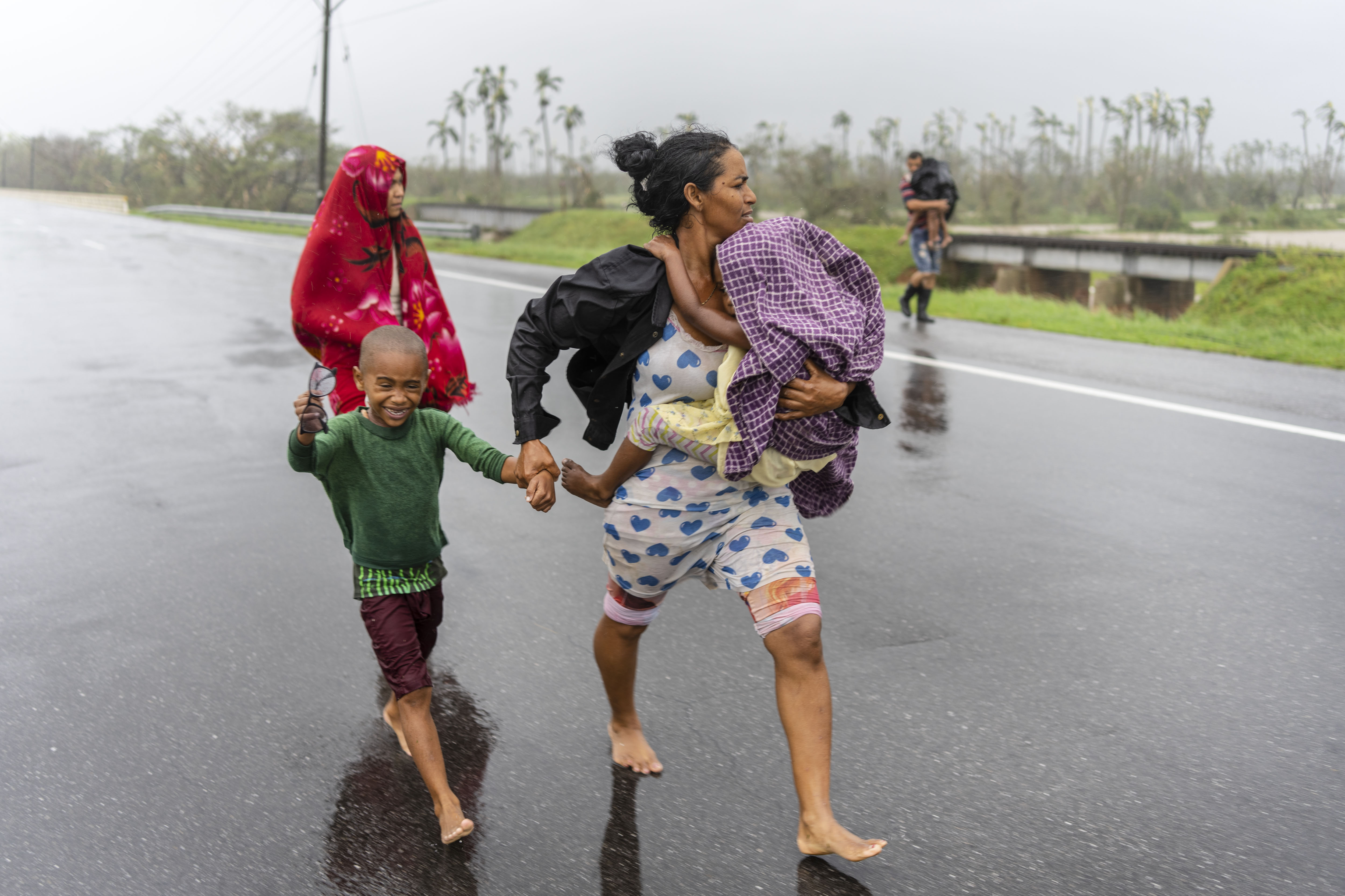 Una familia camina bajo la lluvia en busca de refugio después de que el huracán Ian inundó su casa en Pinar del Río, Cuba. 
