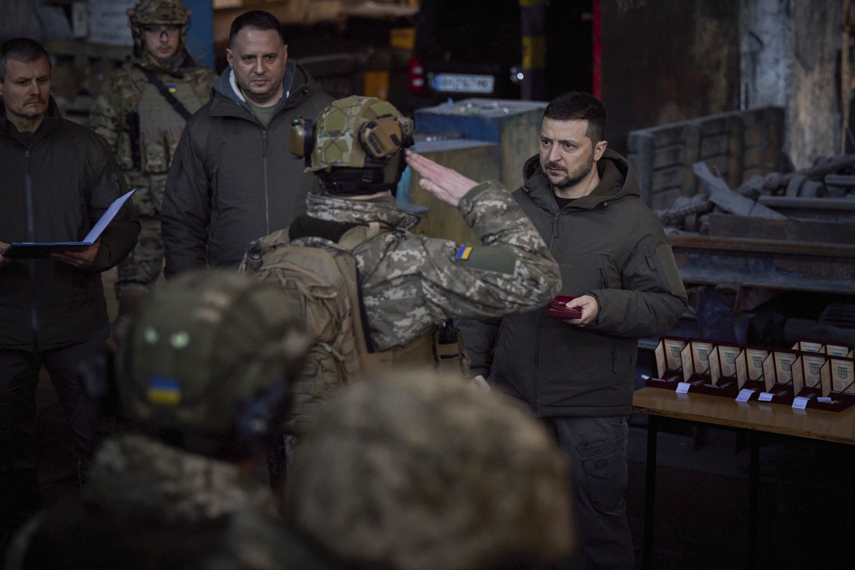En esta imagen proporcionada por la oficina de prensa de la presidencia ucraniana, el presidente de Ucrania, Volodymyr Zelenskyy, a la derecha, entrega una medalla a un militar en la disputada ciudad de Bakhmut, escenario de duras batalla con tropas invasoras rusas, en Ucrania, el martes 20 de dicimebre de 2022. (Oficina de prensa de la presidencia ucraniana via AP)