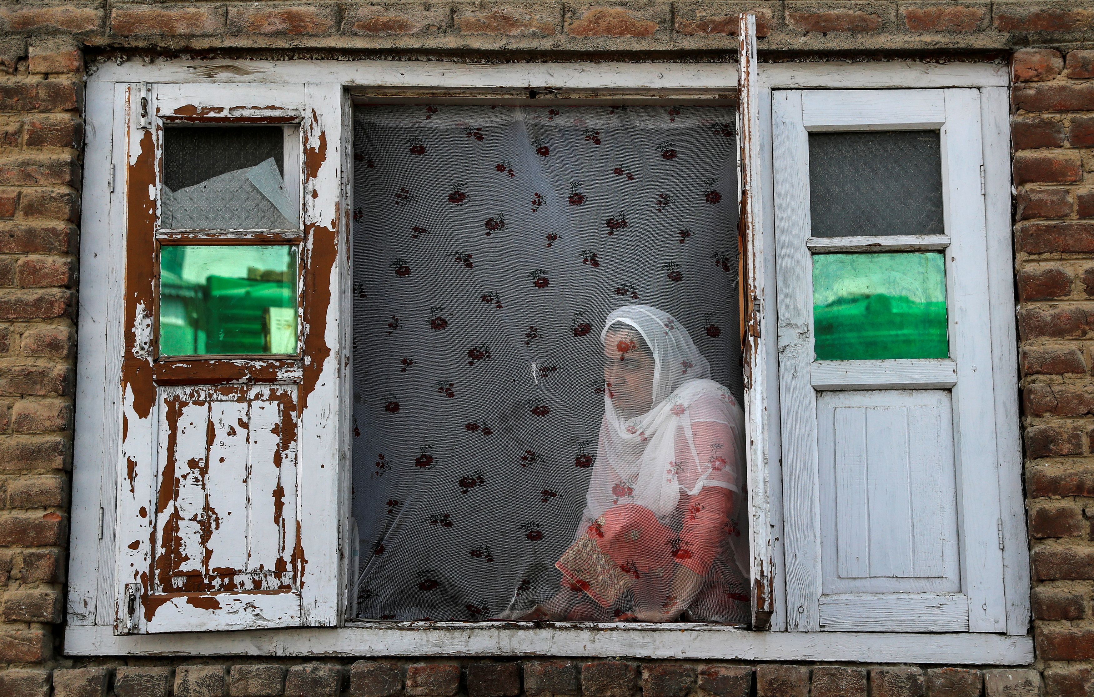 Una mujer de Cachemira observa las protestas en el barrio de Anchar después de las oraciones del viernes, durante las restricciones tras la eliminación del estatus constitucional especial para Cachemira por parte del gobierno indio, en Srinagar el 20 de septiembre de 2019. 