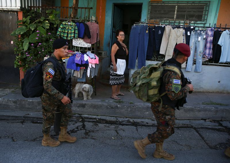 Una mujer mira a las tropas que pasan frente a su tienda (REUTERS/José Cabezas)