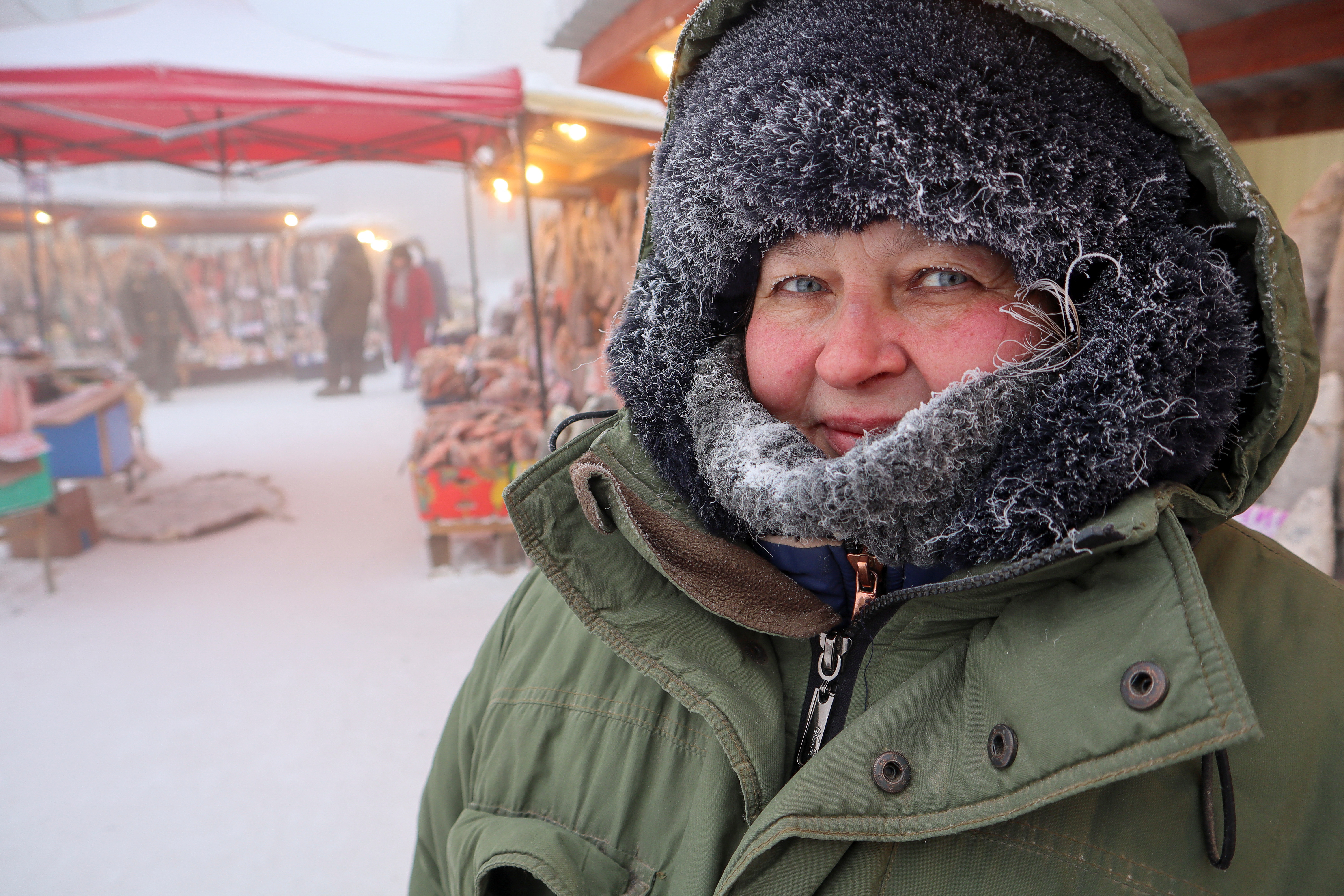 La vendedora Svetlana Belyayeva posa para una foto en un mercado al aire libre en un día gélido en Yakutsk, Rusia, este 15 de enero de 2023 (Reuters)