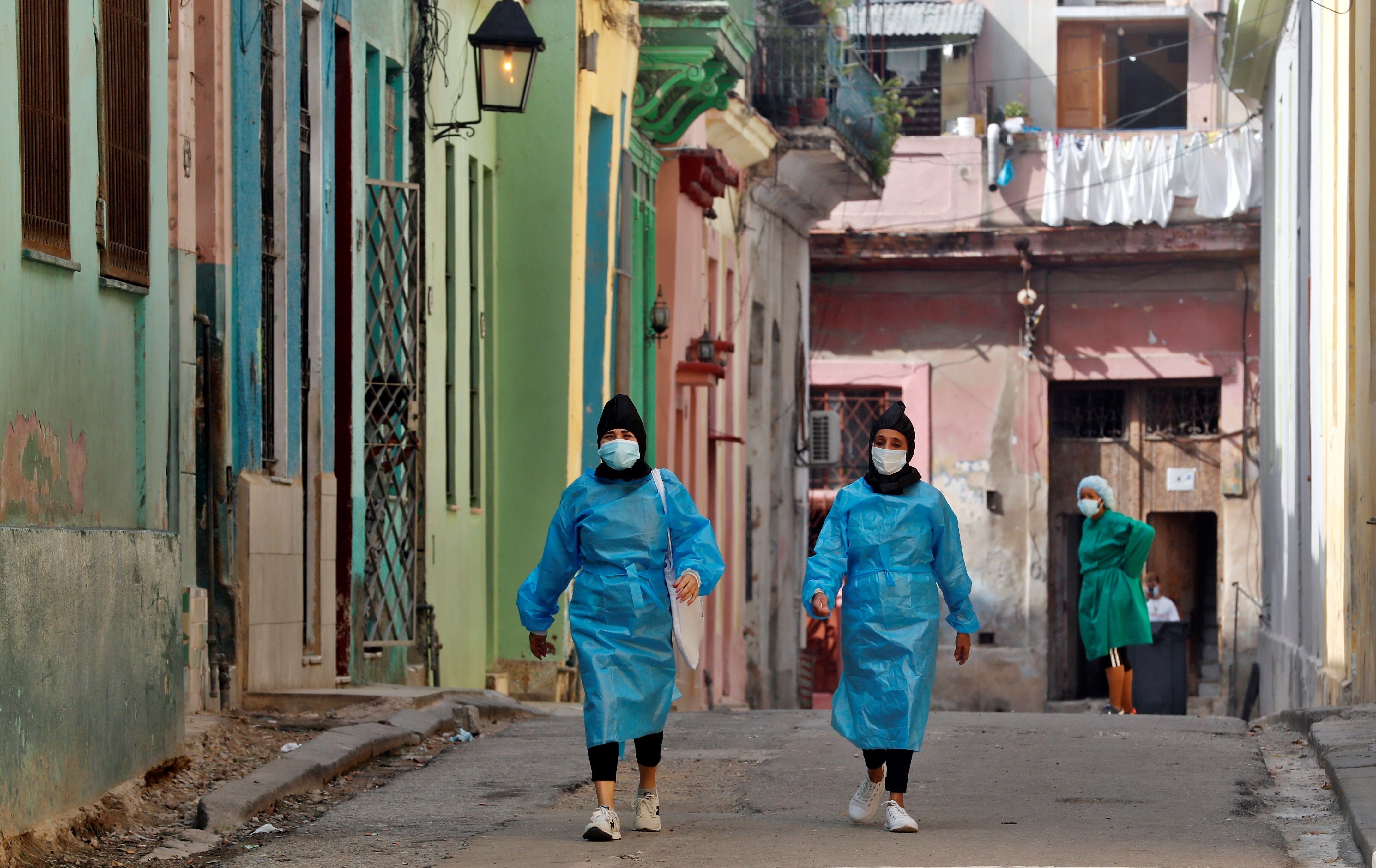 Trabajadoras de la salud recorren el 24 de febrero de 2021 una calle cerrada por la pandemia, en La Habana (Cuba). EFE/ Ernesto Mastrascusa
