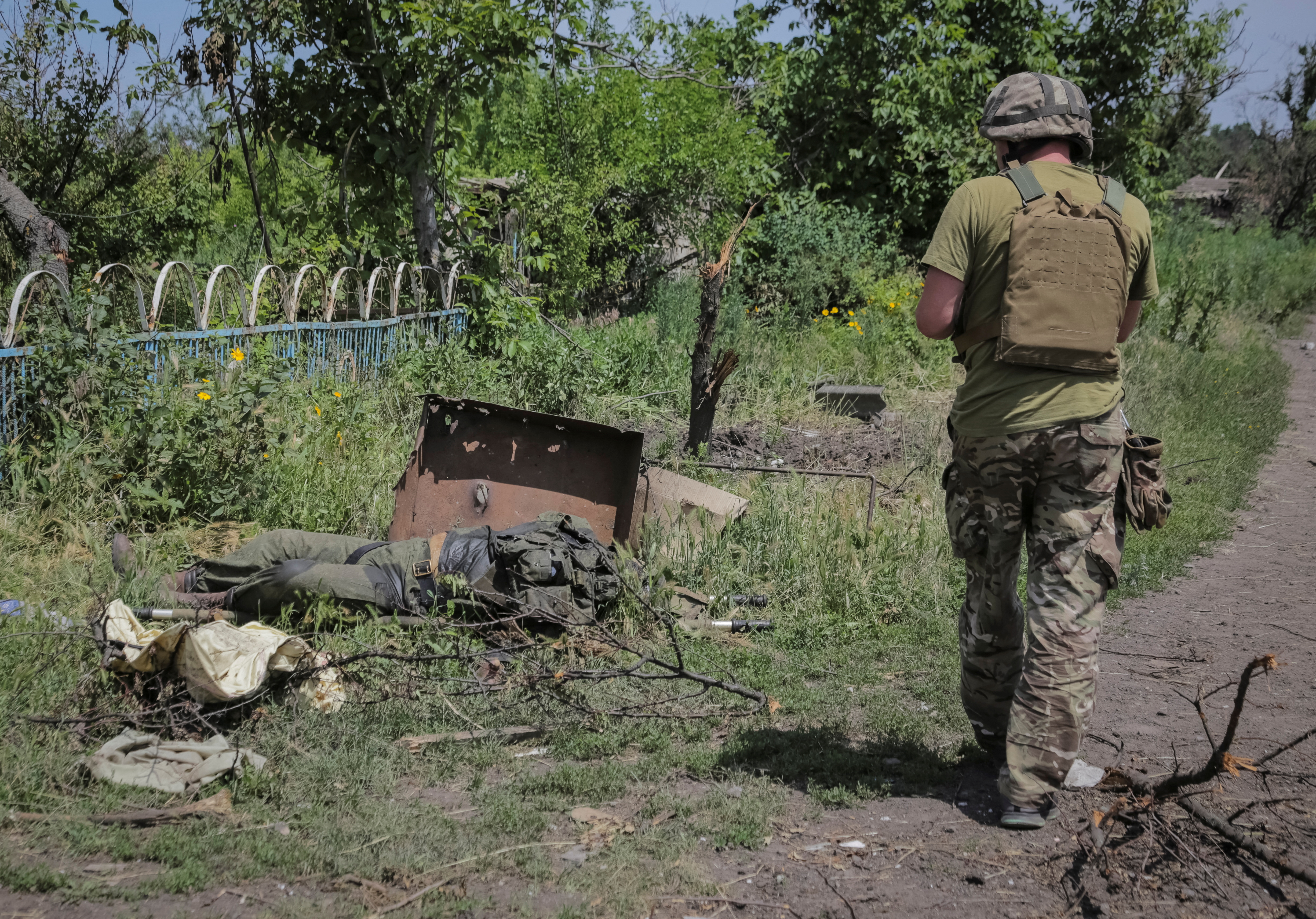 El cuerpo de un soldado ruso que voló por los aires yace junto a un vehículo militar ruso abandonado (REUTERS/Oleksandr Ratushniak)