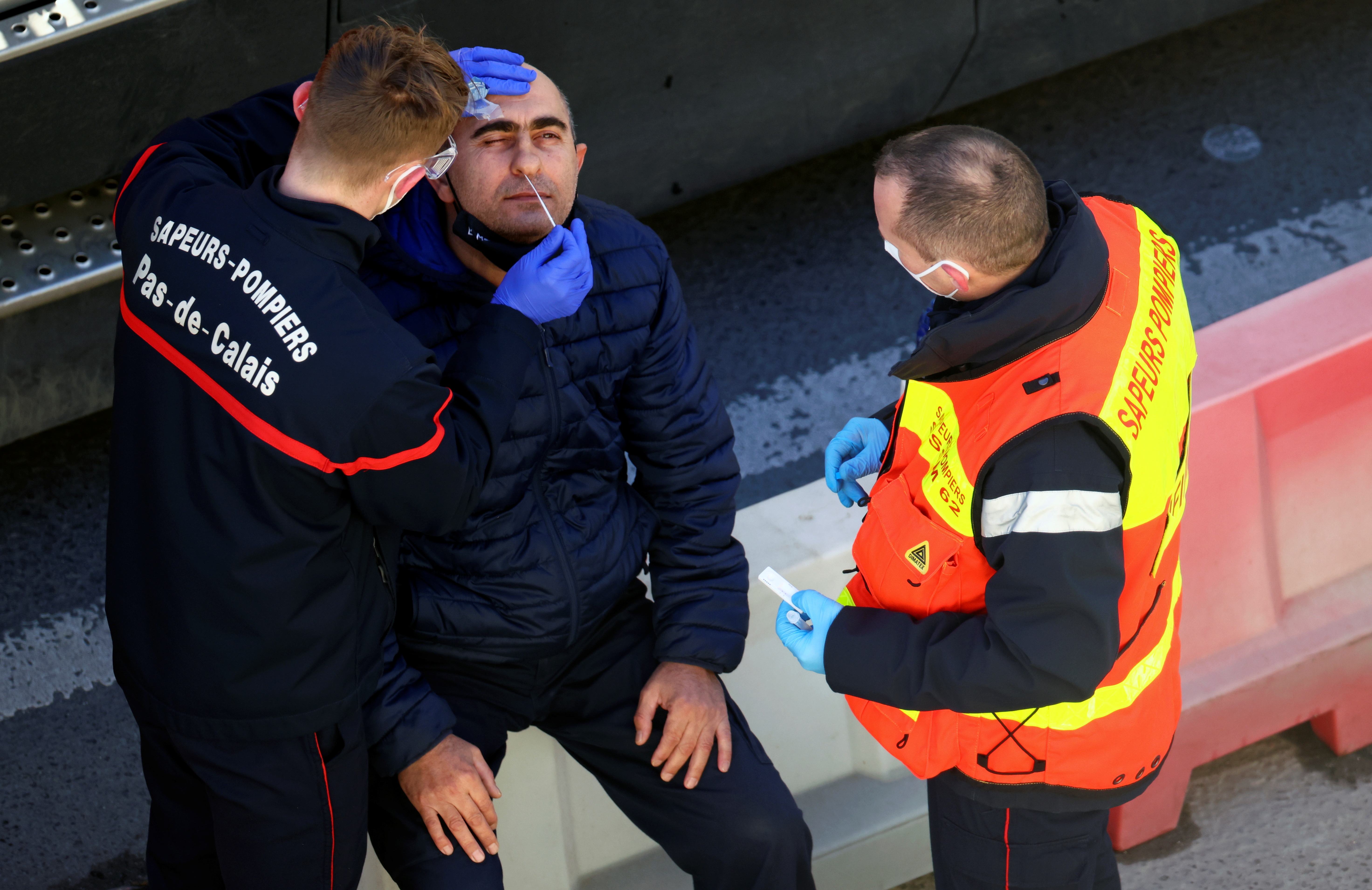 Funcionarios franceses hisopan a un conductor británico en el Puerto de Dover, el 25 de diciembre de 2020 (REUTERS/Henry Nicholls)