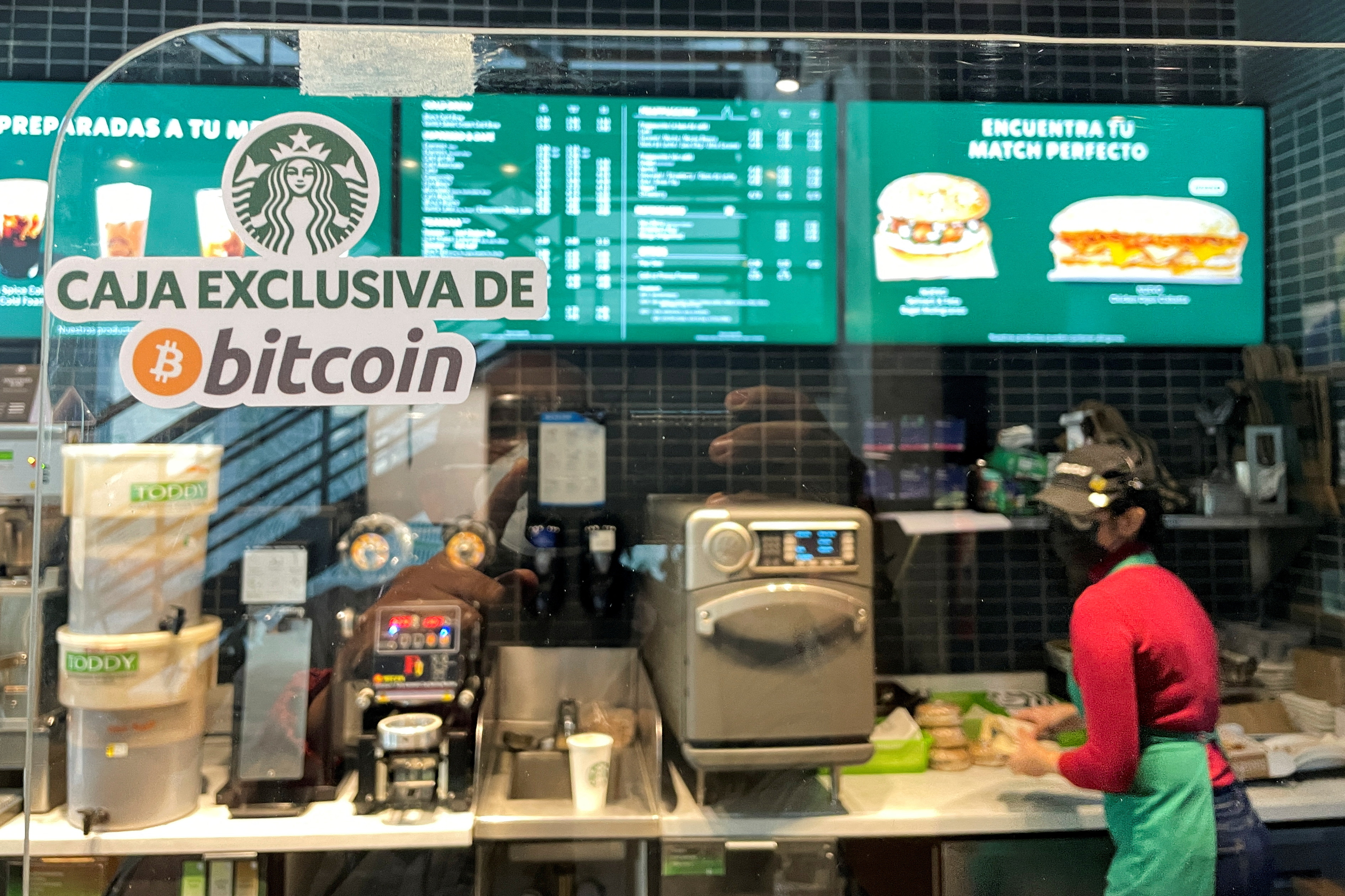 FILE PHOTO: A sign reads: "Exclusive Bitcoin register" in a Starbucks store where the cryptocurrency is accepted as a payment method, in San Salvador, El Salvador September 7, 2021. REUTERS/Jose Cabezas/File Photo