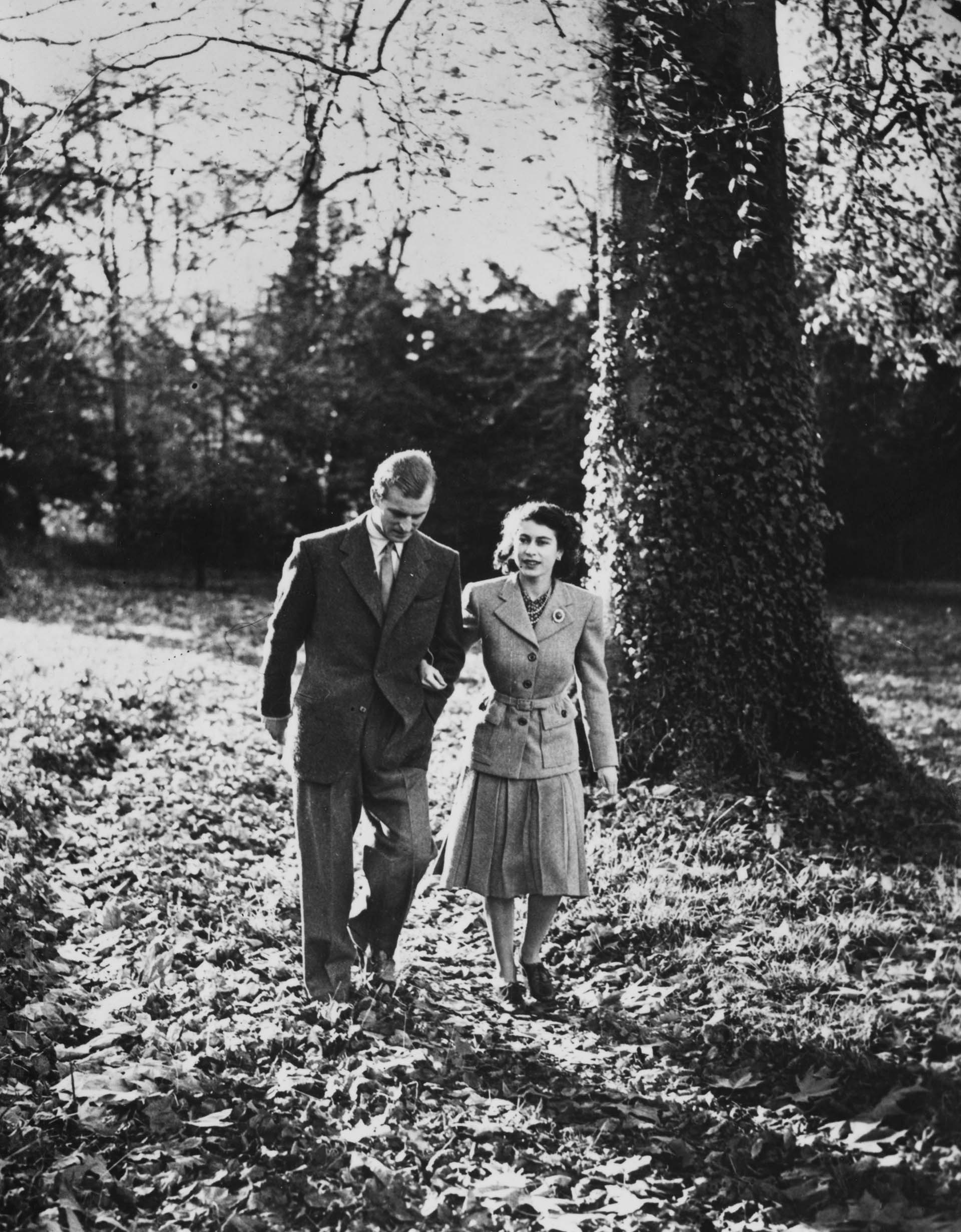 24 de noviembre de 1947:  La princesa Isabel (más tarde la reina Isabel II) y el duque de Edimburgo de luna de miel en Broadlands, cerca de Romsey, Hampshire, paseando por la finca de Broadlands después de un servicio en la abadía de Romsey. (Photo by Topical Press Agency/Getty Images)