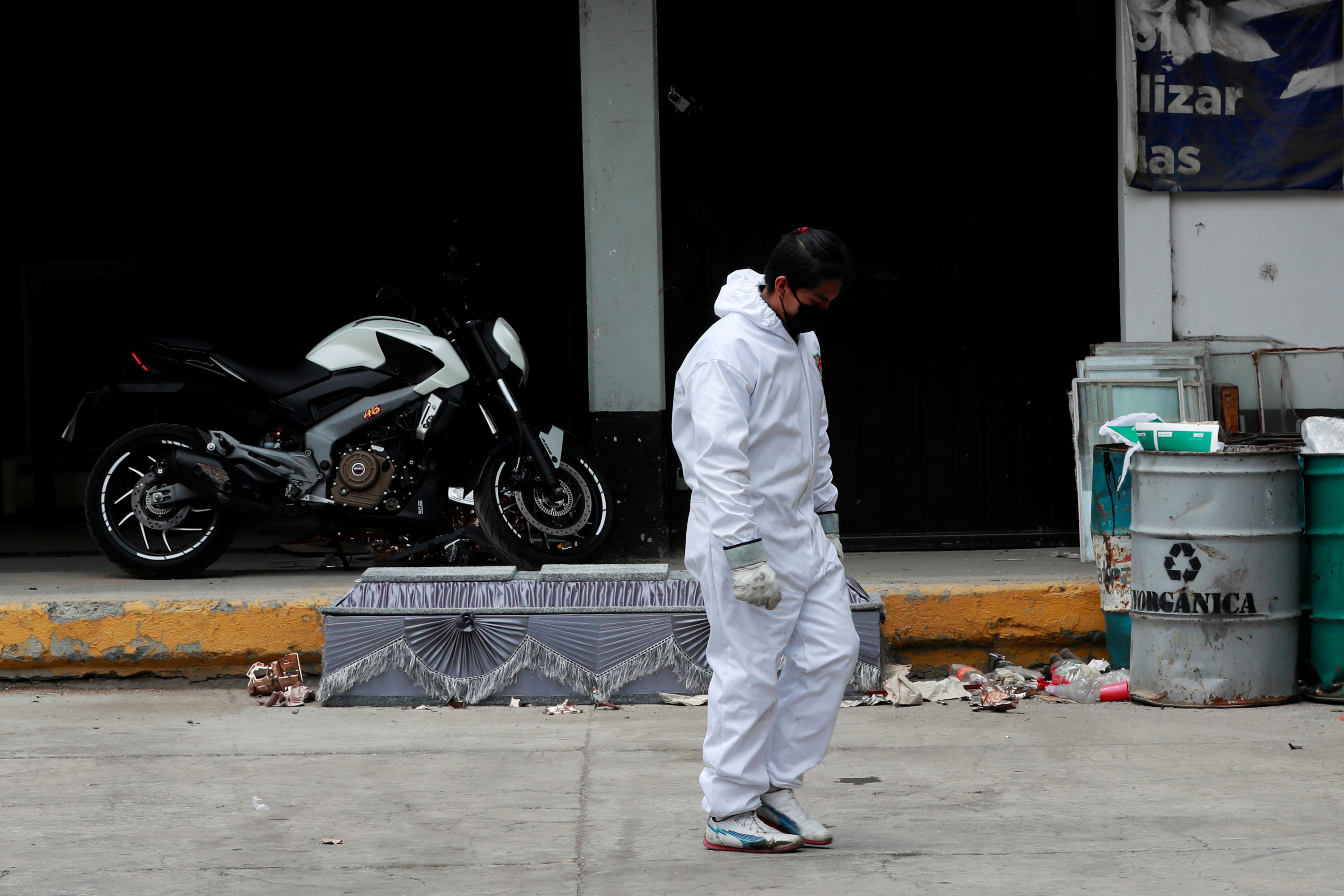 El trabajador de un cementerio utiliza un traje protector afuera de un cuarto de cremación durante la pandemia de COVID-19 en la Ciudad de México (Foto: Reuters/Carlos Jasso)