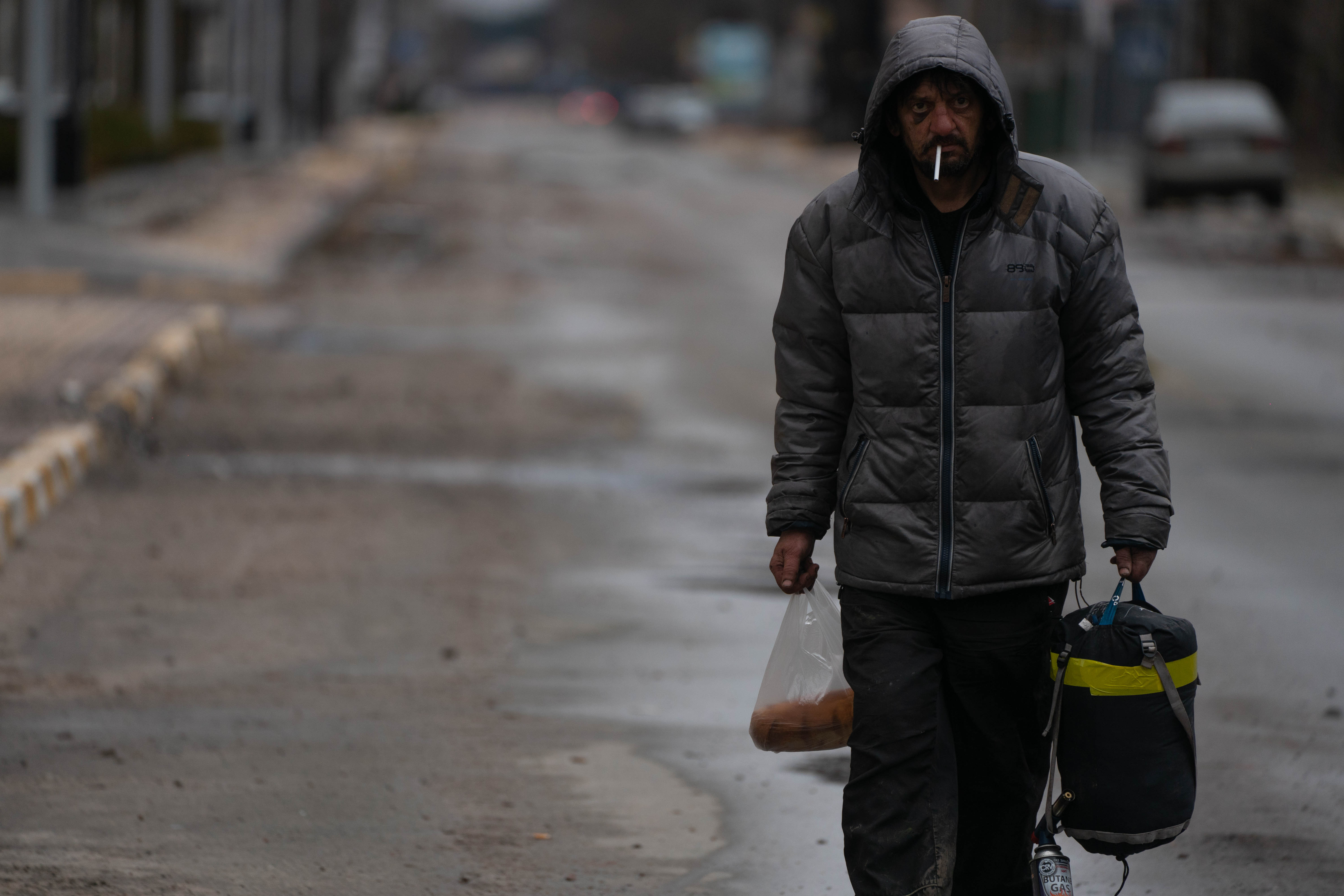 Pan y una bolsa de dormir, un vecino de Irpin regresa a su ciudad para pasar la noche en los primeros dias después de que la ciudad fuera liberada por el ejercito ucraniano.