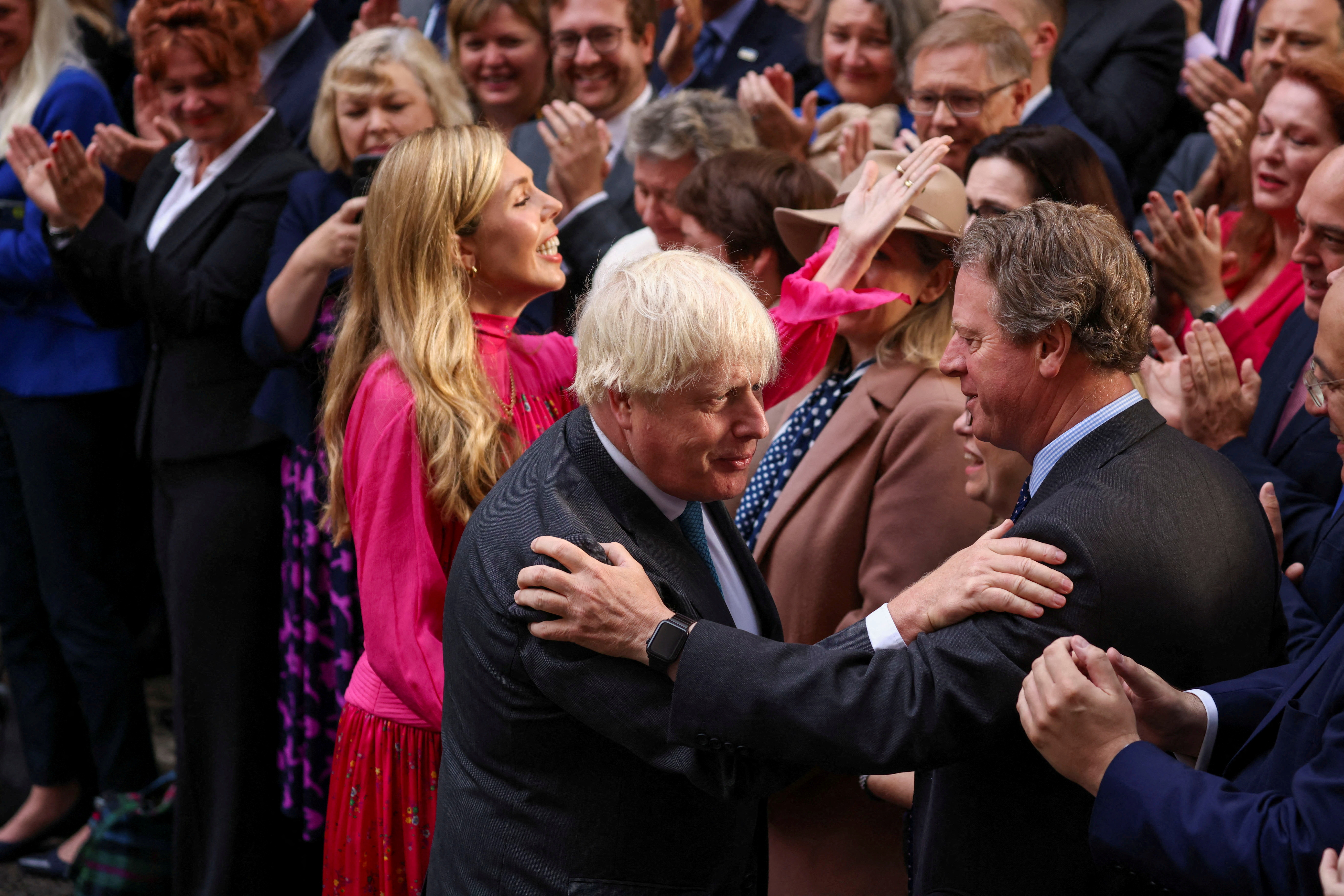 El primer ministro británico saliente, Boris Johnson, con su esposa Carrie Johnson, saluda a la gente después de pronunciar un discurso en su último día en el cargo, en las afueras de Downing Street (REUTERS/Henry Nicholls)