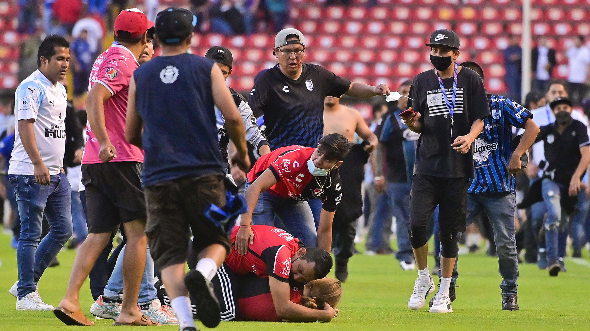 Aficionados del Querétaro y aficionados del Atlas originaron un conato de pelea que terminó invadiendo la cancha, en el estadio Corregidora (Foto: EFE)
