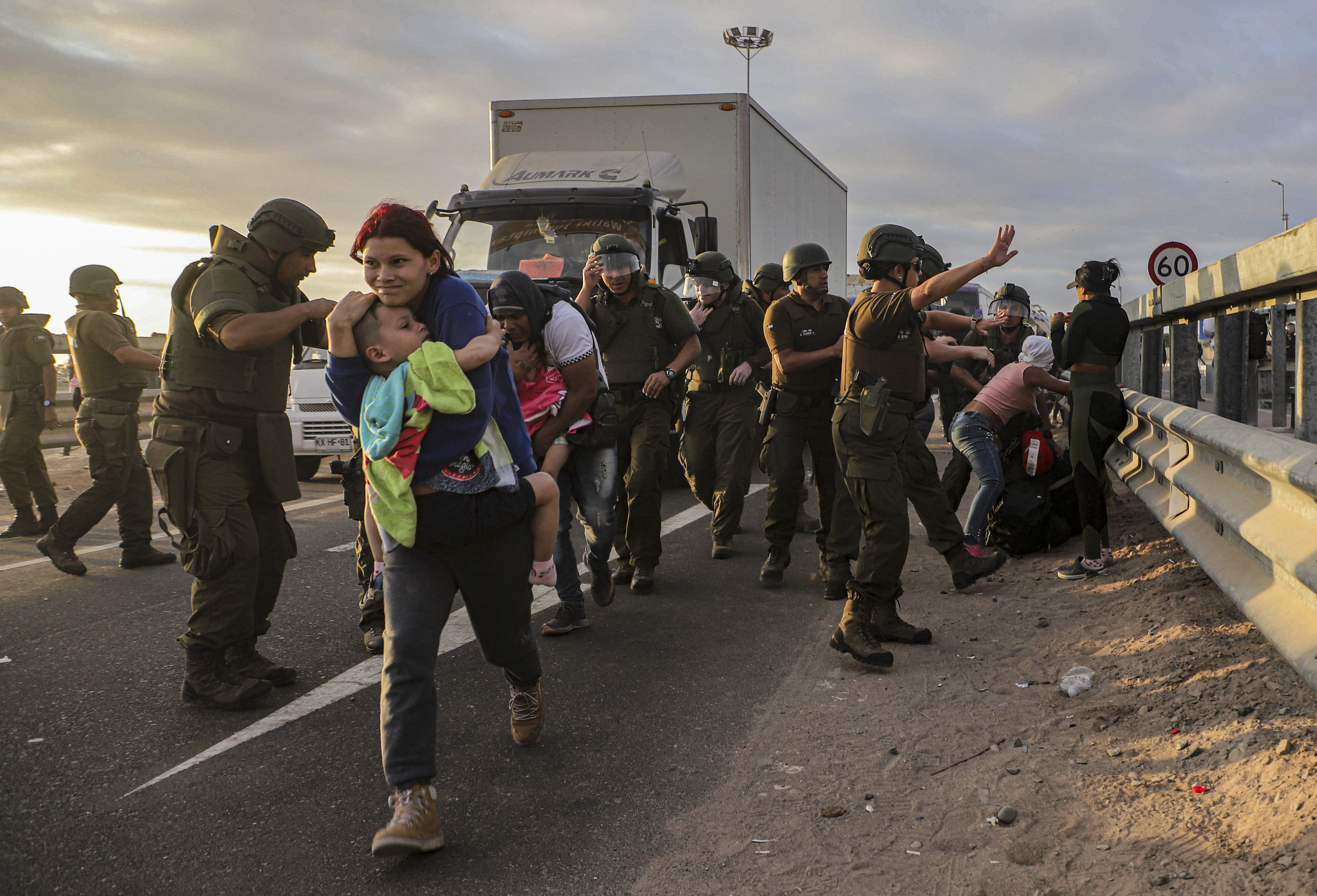 Migrants blocking the road on the Chile-Peru border are dispersed by Chilean police near Arica, Chile, Tuesday, May 2, 2023. A migration crisis on the Chile-Peru border escalated in the presence of migrants, mostly Venezuelans, who are stranded on the border between the two countries on their way back home.  (AP Photo/Agustin Mercado)