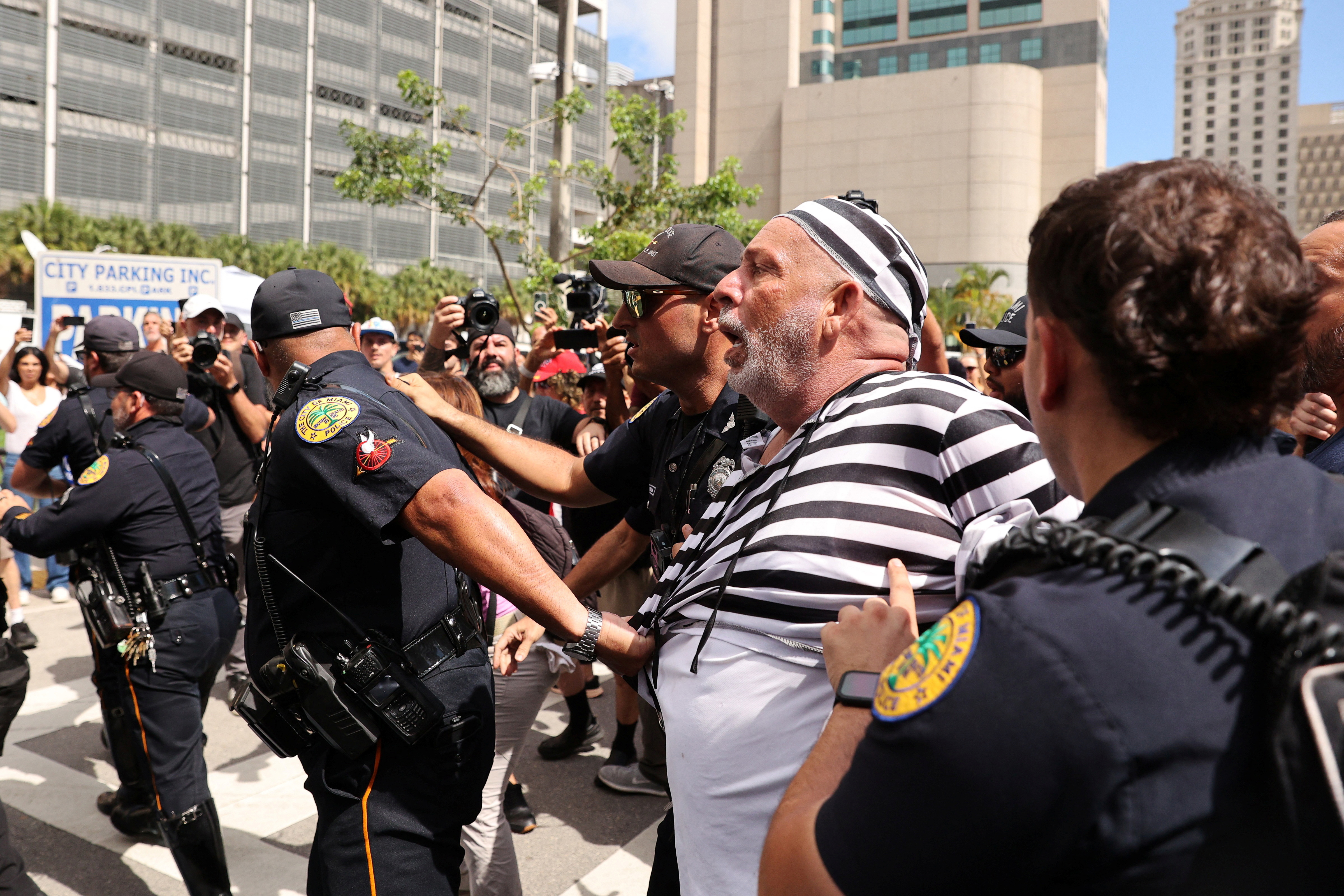 Un manifestante con traje de presidiario que se plantó delante de la comitiva fue reducido por la Policía local (REUTERS/Marco Bello)