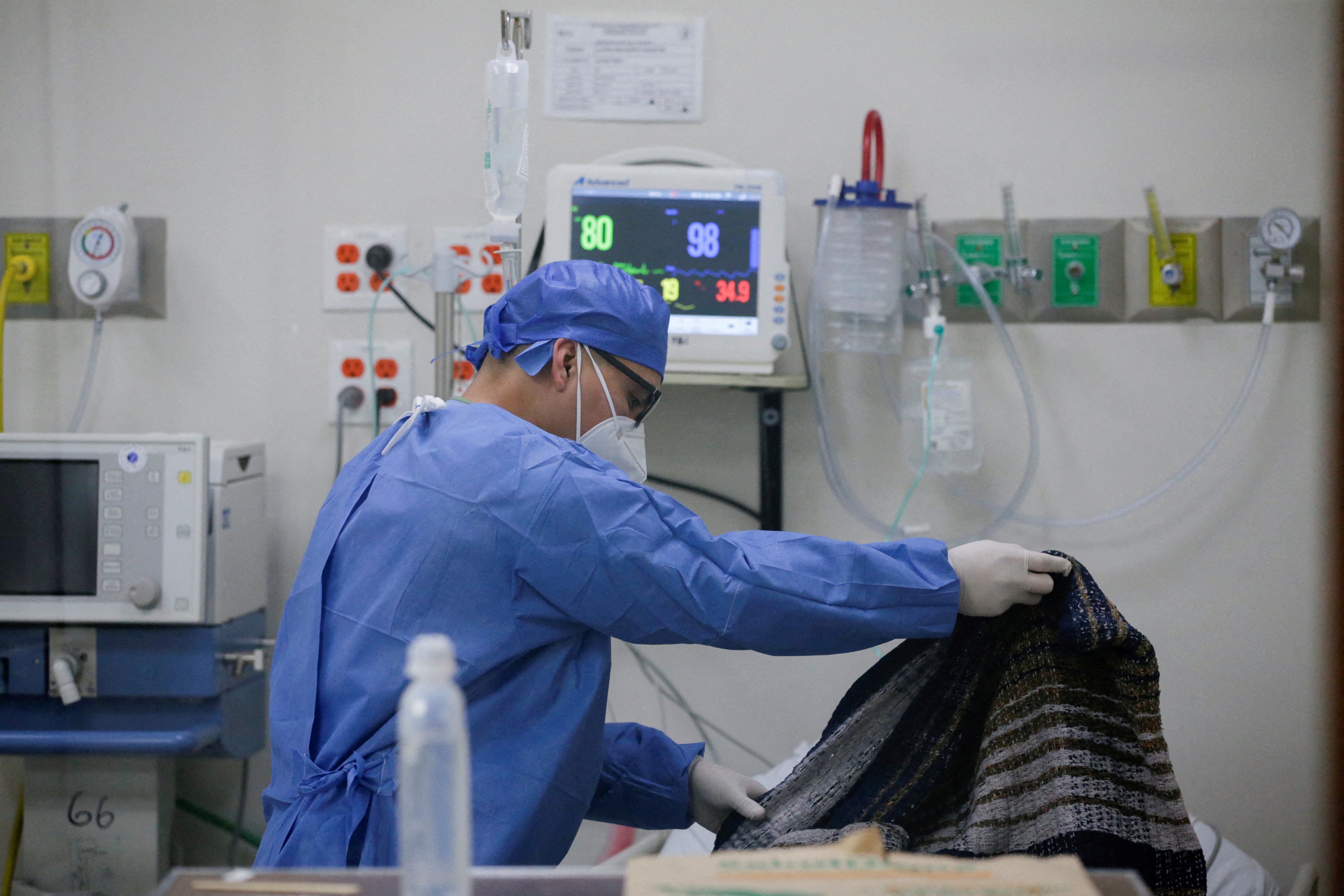 Un miembro del personal médico cubre con una manta a un paciente con COVID-19 en la sala de emergencias del Hospital Metropolitano en Monterrey (Foto: Reuters)