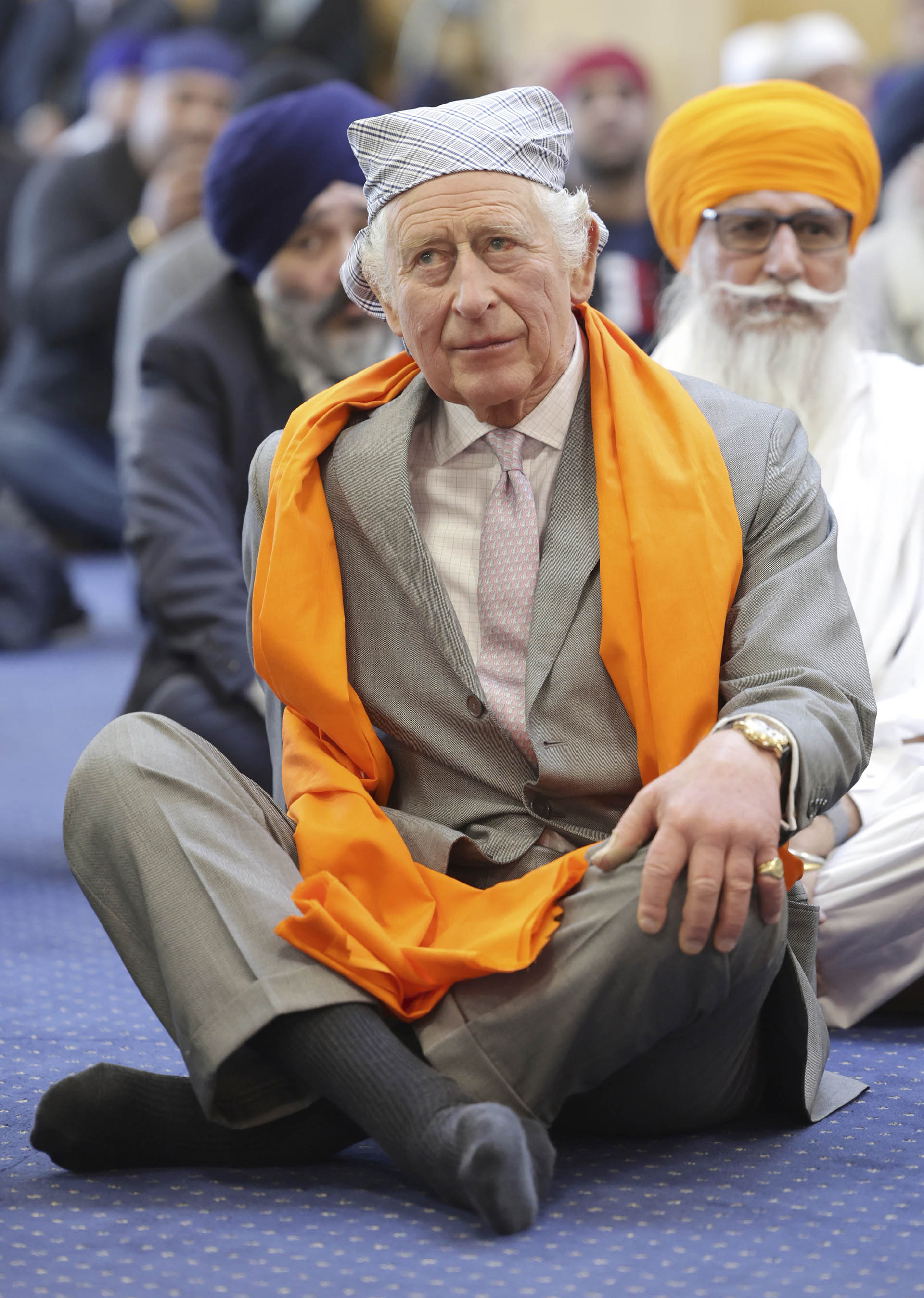 ARCHIVO - El rey Carlos III de Gran Bretaña se sienta en el piso de la Sala de oración durante una visita al recién construido Guru Nanak Gurdwara, en Luton, Inglaterra, el martes 6 de diciembre de 2022. (Chris Jackson/Pool Photo vía AP, archivo)
