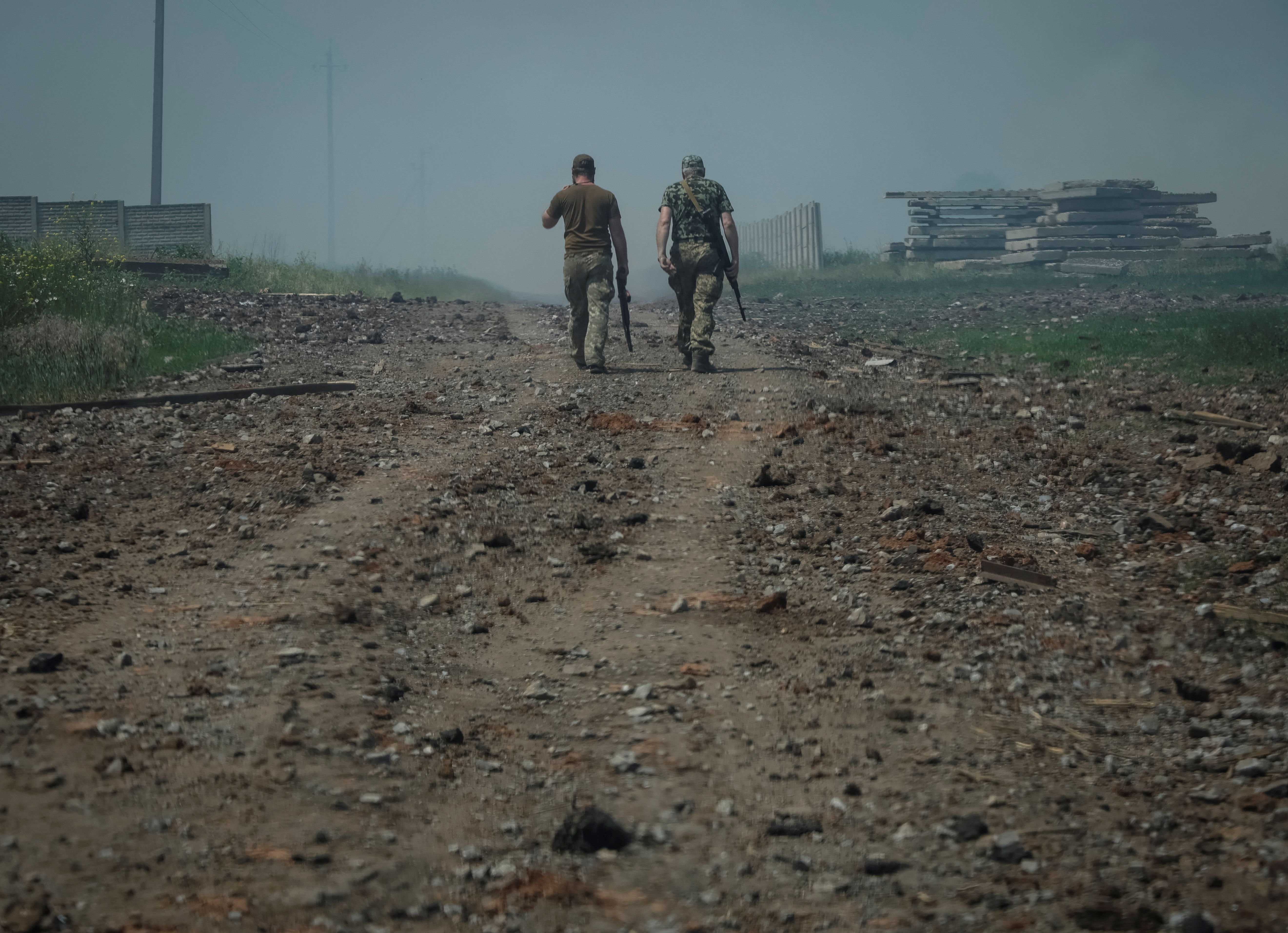 Miembros del servicio ucraniano caminan por la carretera cerca de la ciudad de Soledar, en medio de la invasión rusa de Ucrania, región de Donetsk, Ucrania 8 de junio de 2022 (Reuters)