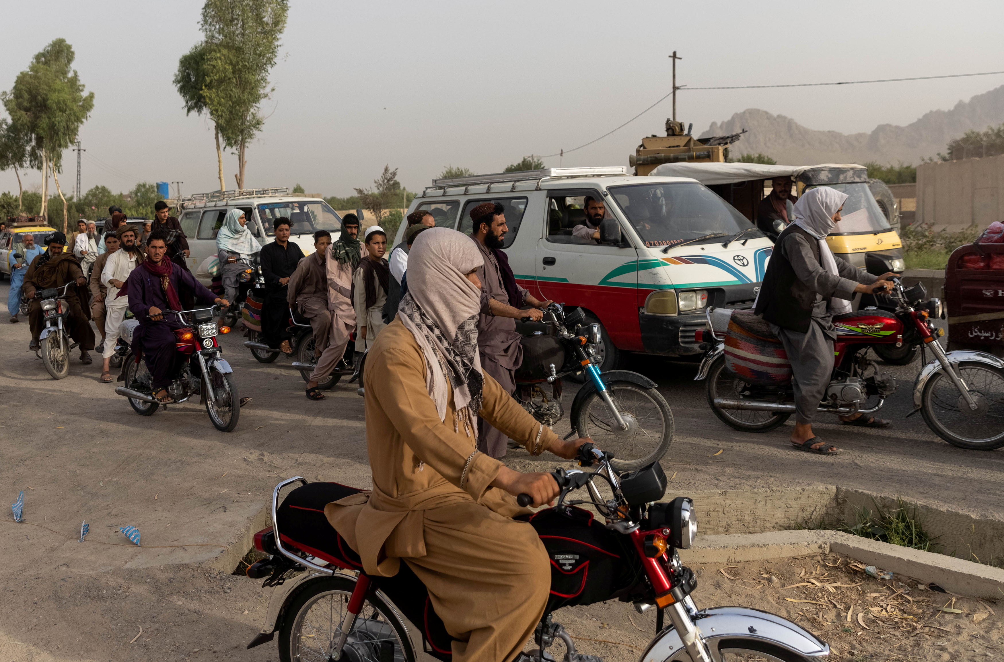 El tráfico se detiene mientras miembros de las fuerzas especiales afganas se reagrupan tras fuertes enfrentamientos con los talibanes durante la misión de rescate de un policía asediado en un puesto de control, en la provincia de Kandahar, Afganistán, el 13 de julio de 2021.