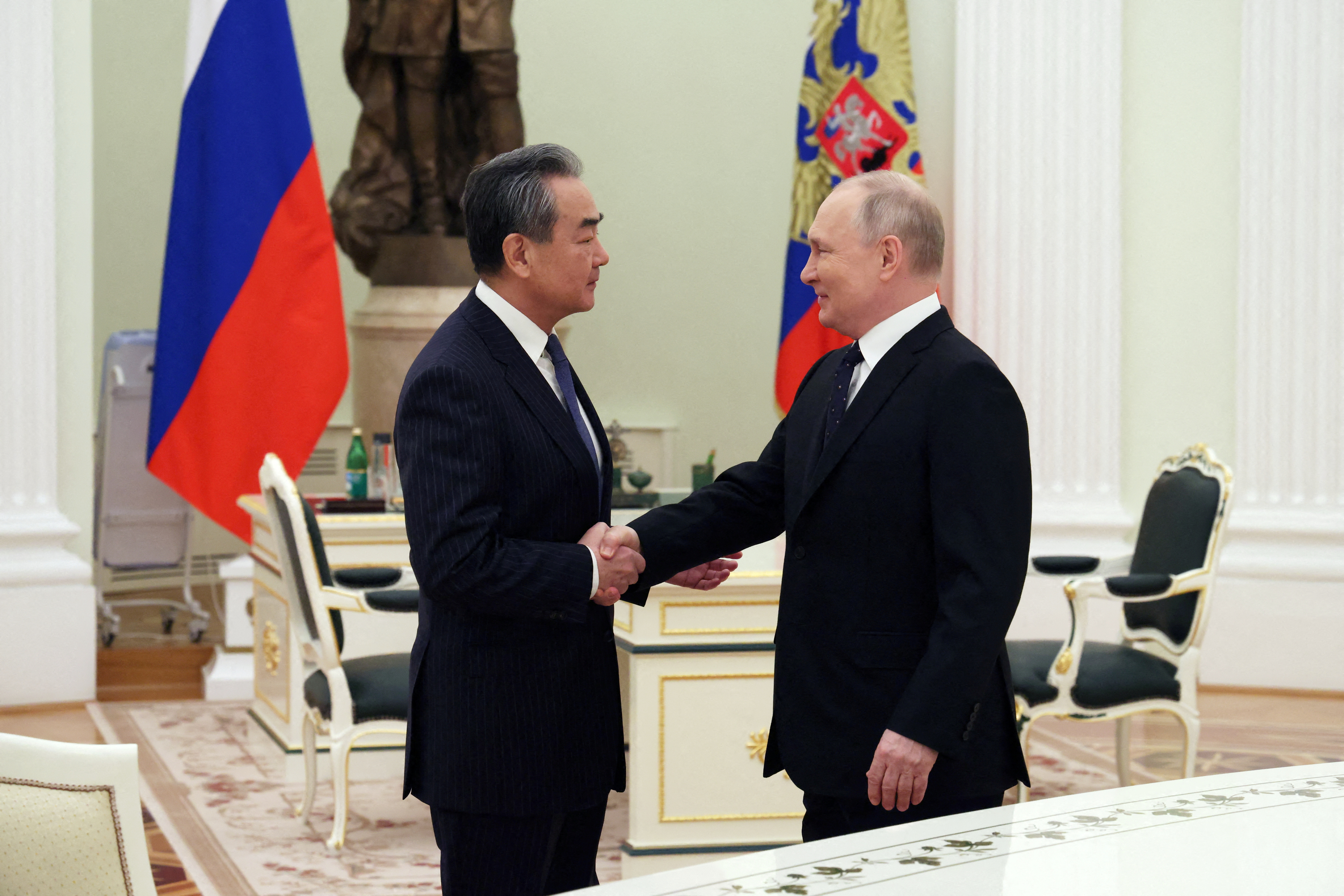 Vladimir Putin recibe en el Kremlin al director de la oficina de Relaciones Internacionales del Partido Comunista Chino, Wang Yi. (Sputnik/Anton Novoderezhkin/Pool via REUTERS) 