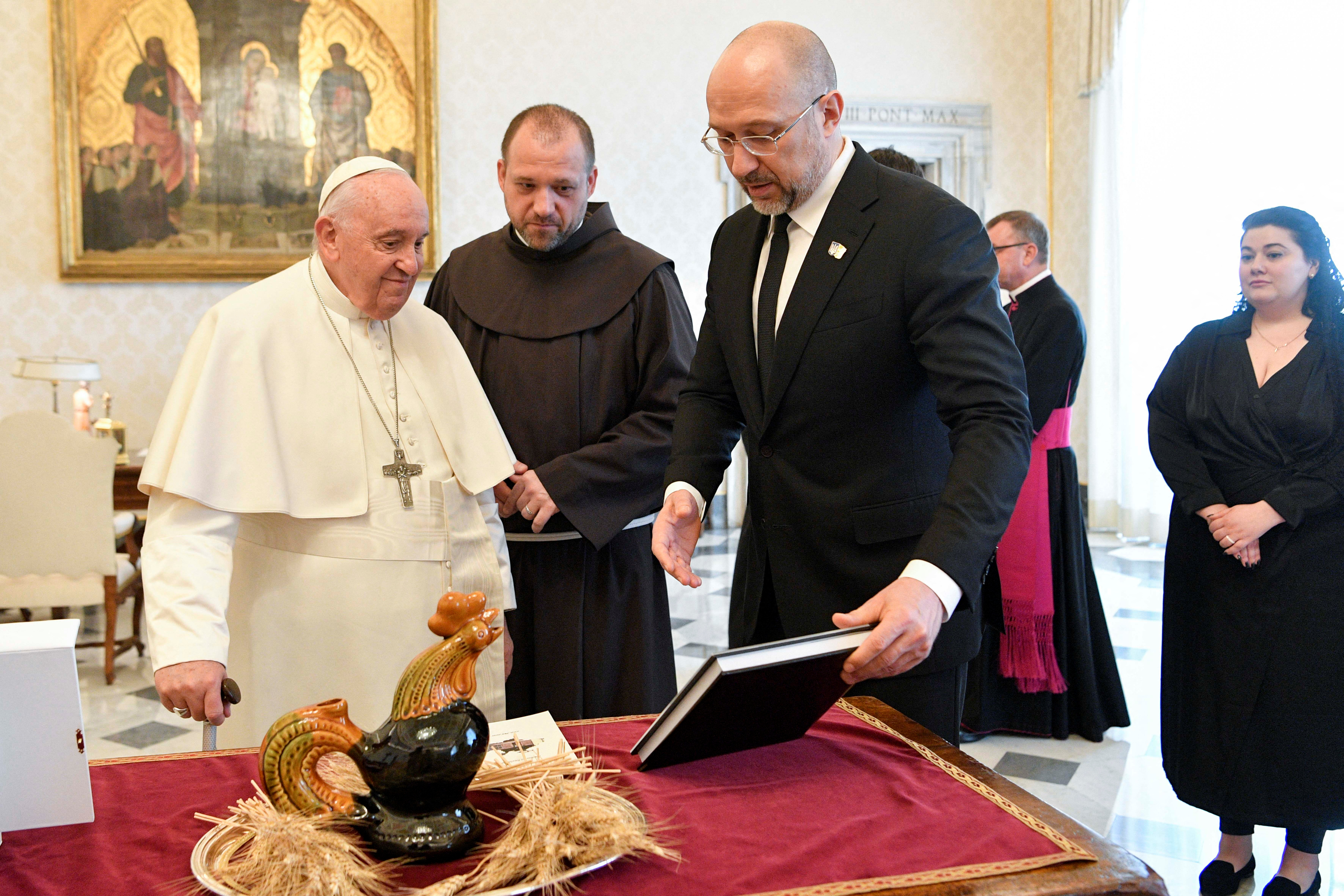 The prime minister presented the pontiff with a reproduction of a ceramic jug depicting a rooster, which was found in a house near Kiev after a bombing raid, and also offered a photo book about the ongoing war and the resistance of the Ukrainian people ( Vatican Media/REUTERS)