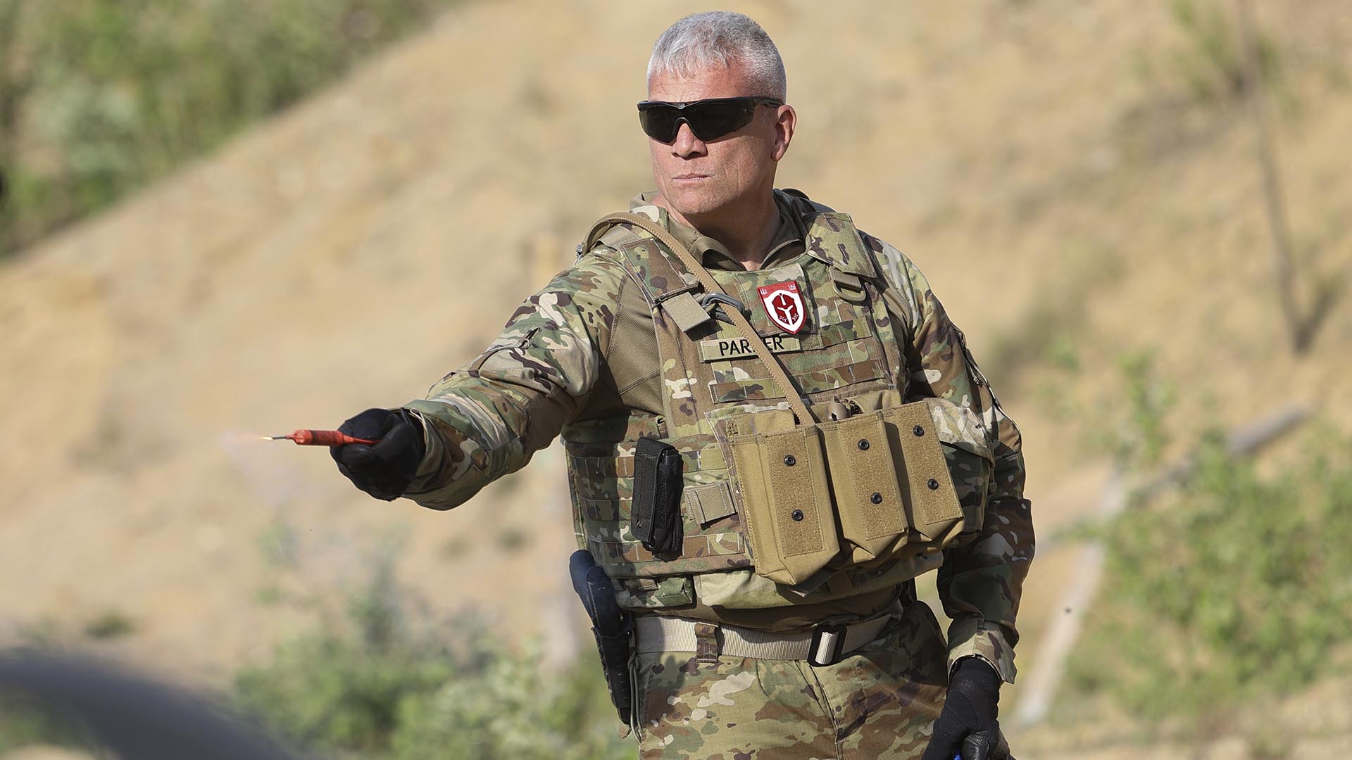 El ex miembro del ejército estadounidense, Matthew Parker, sostiene una granada de humo durante una sesión de entrenamiento para voluntarios bielorrusos en un campo de tiro cerca de Varsovia, Polonia. (Foto AP/Michal Dyjuk)
