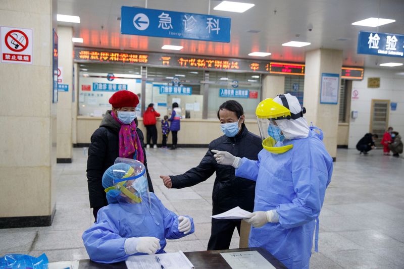 Enfermeras con equipo de protección hablan con las personas en la recepción del First People's Hospital, en Yueyang en enero de 2020 (REUTERS/Thomas Peter)