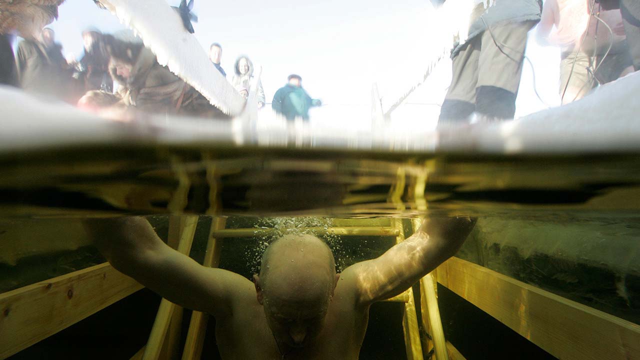 Imagen de archivo de un hombre dentro del agua helada durante el festejo de la Epifanía ortodoxa