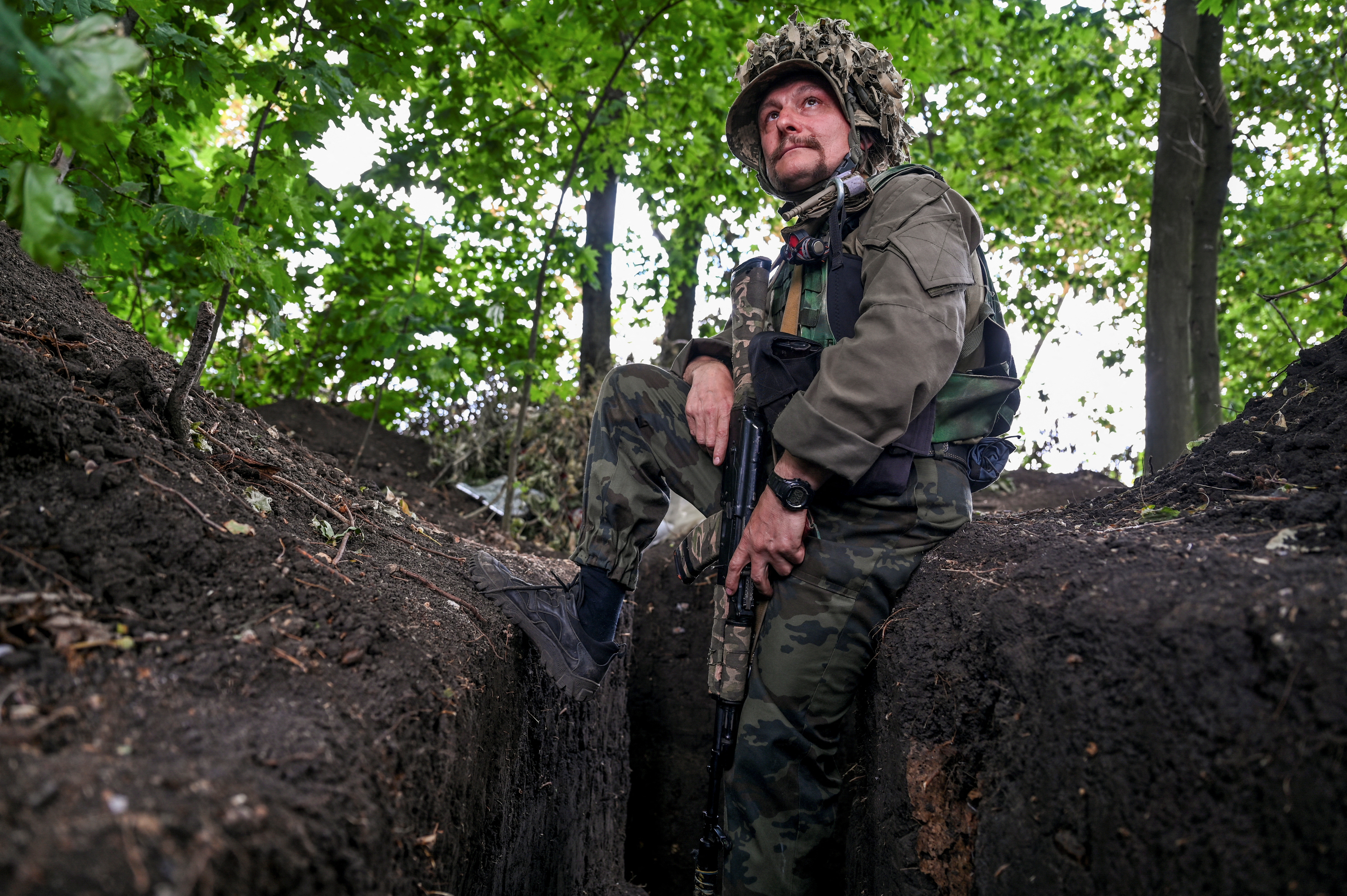 Un militar ucraniano se sienta en una trinchera en una posición cerca de la línea del frente, mientras continúa el ataque de Rusia contra Ucrania, en la región de Zaporizhzhia, Ucrania, 17 de julio de 2022 (REUTERS/Dmytro Smolienko)