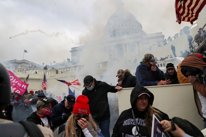 Partidarios del presidente cubriendo sus caras para protegerse del gas lacrimógeno durante un enfrentamiento con agentes de la policía frente al Capitolio en Washington, Estados Unidos. 6 de enero, 2021. (REUTERS/Leah Millis/Archivo)