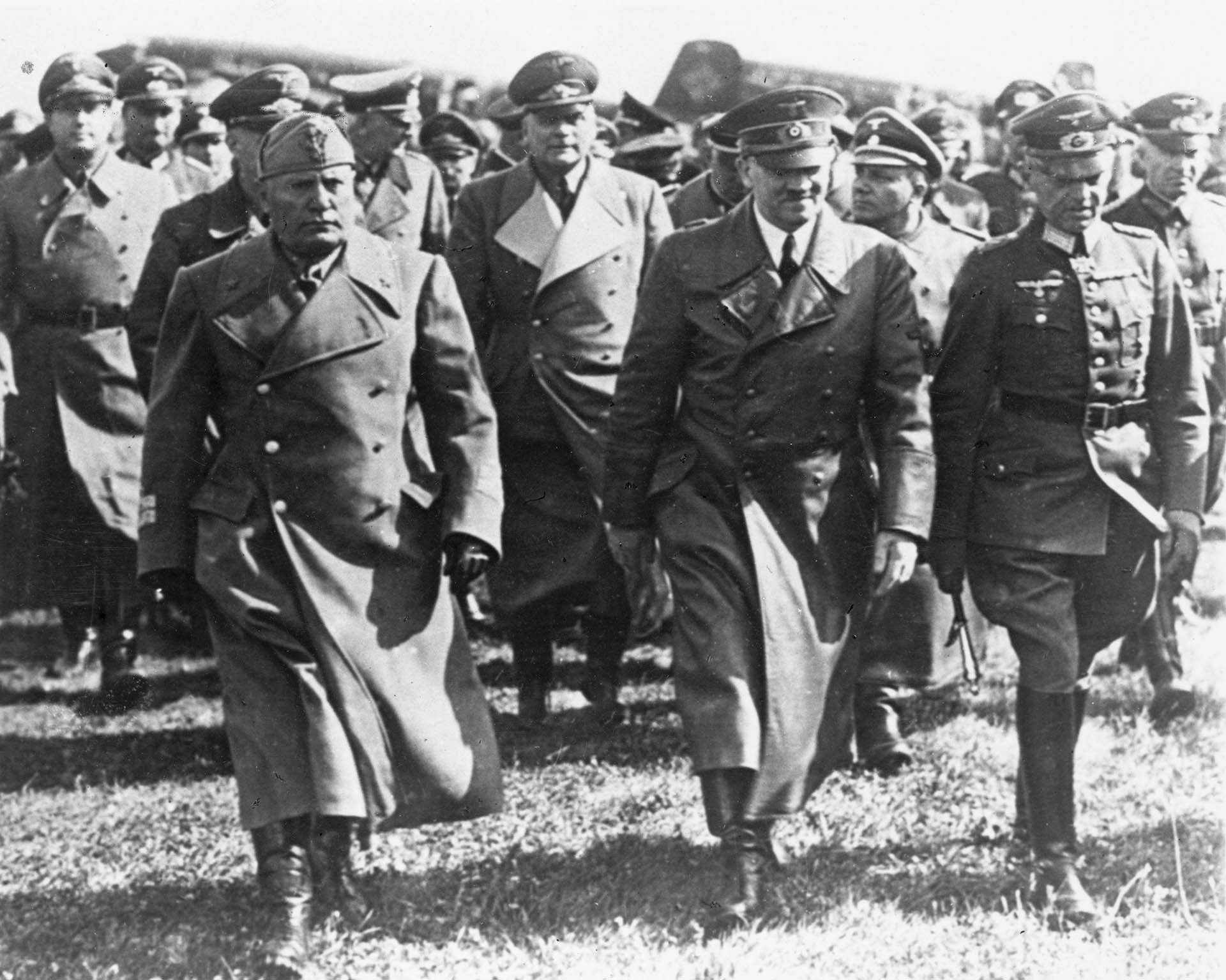 Mayo de 1941: el primer ministro italiano Benito Mussolini con importantes integrantes del gobierno nazi, incluido el dictador alemán Adolf Hitler, durante una visita a Alemania durante la Segunda Guerra Mundial. Detrás de Hitler está su secretario, Martin Bormann (Keystone/Getty Images)
