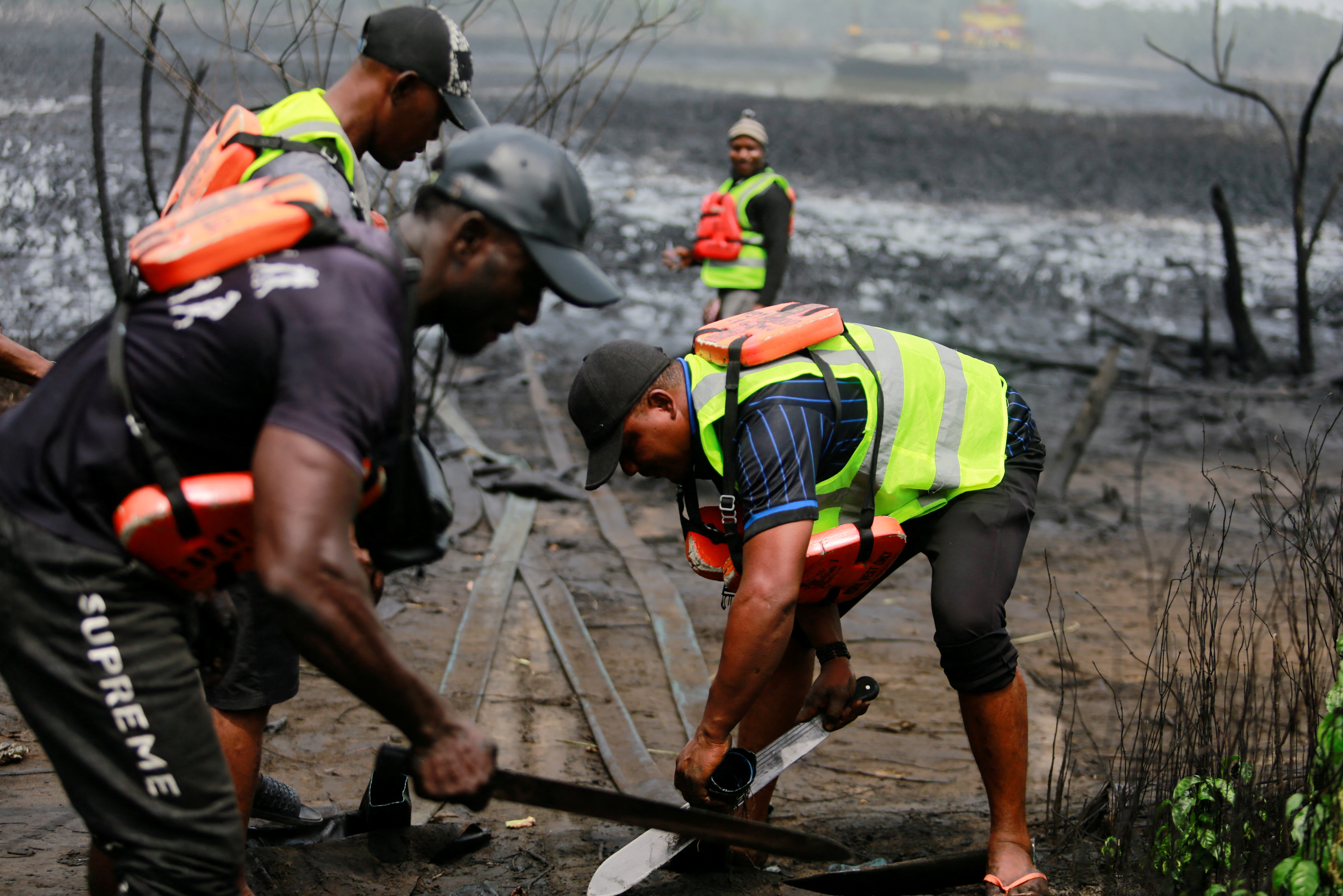 Los miembros del grupo de trabajo sobre el abastecimiento ilegal de petróleo crudo y la refinería artesanal destruyen un campamento Bakana ii, en Okrika, estado de Rivers, Nigeria, el 28 de enero de 2022 (REUTERS/Afolabi Sotunde)