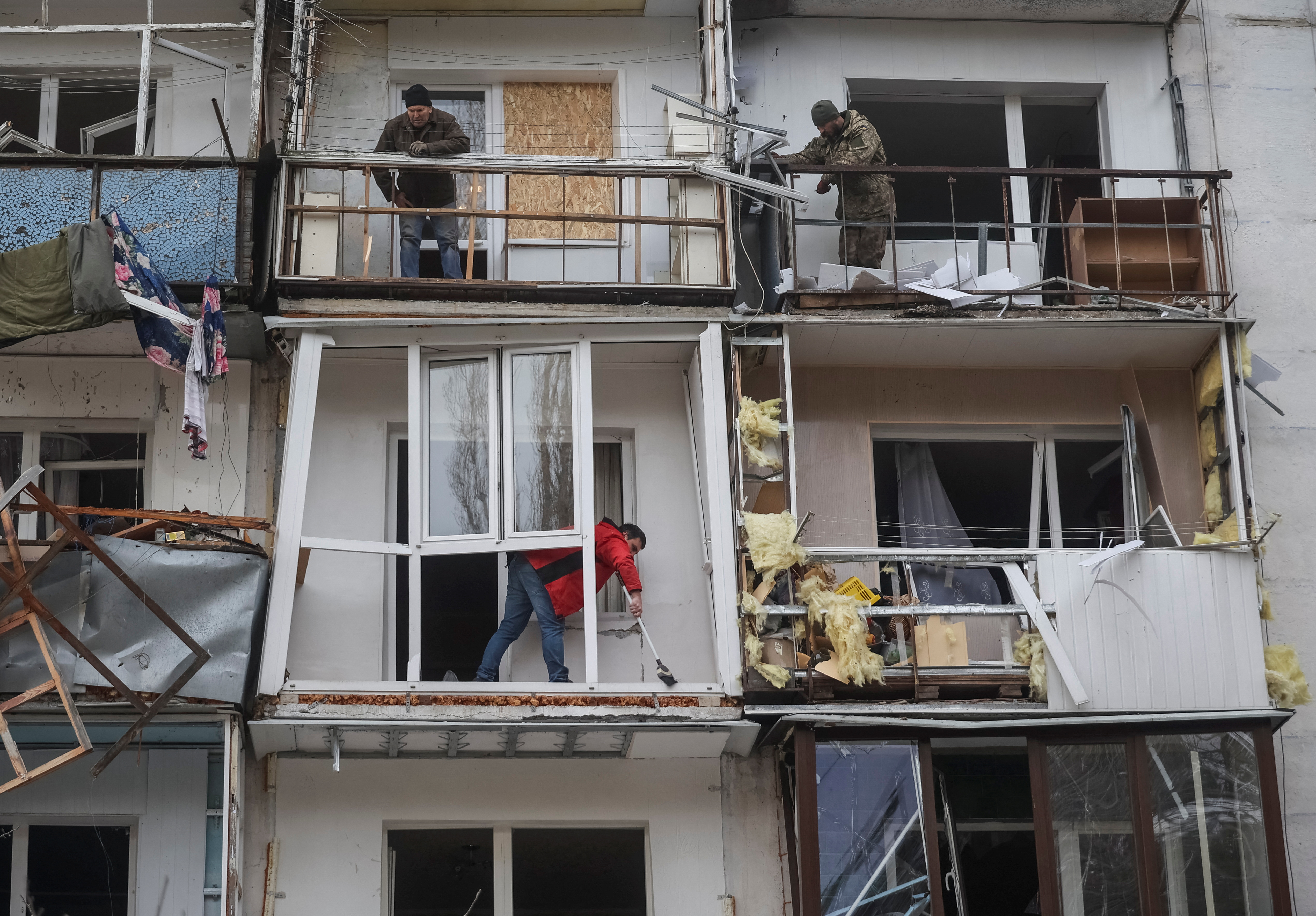 Vecinos en un edificio bombardeado de Kharkiv (Reuters)