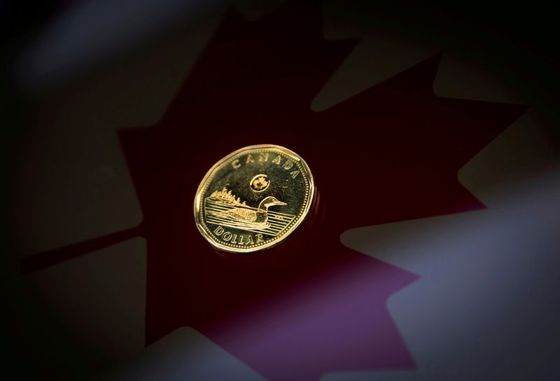 FOTO DE ARCHIVO: Una moneda de un dólar canadiense sobre la bandera de Canadá en esta imagen de ilustración tomada el 23 de enero de 2015 en Toronto, Canadá. REUTERS/Mark Blinch