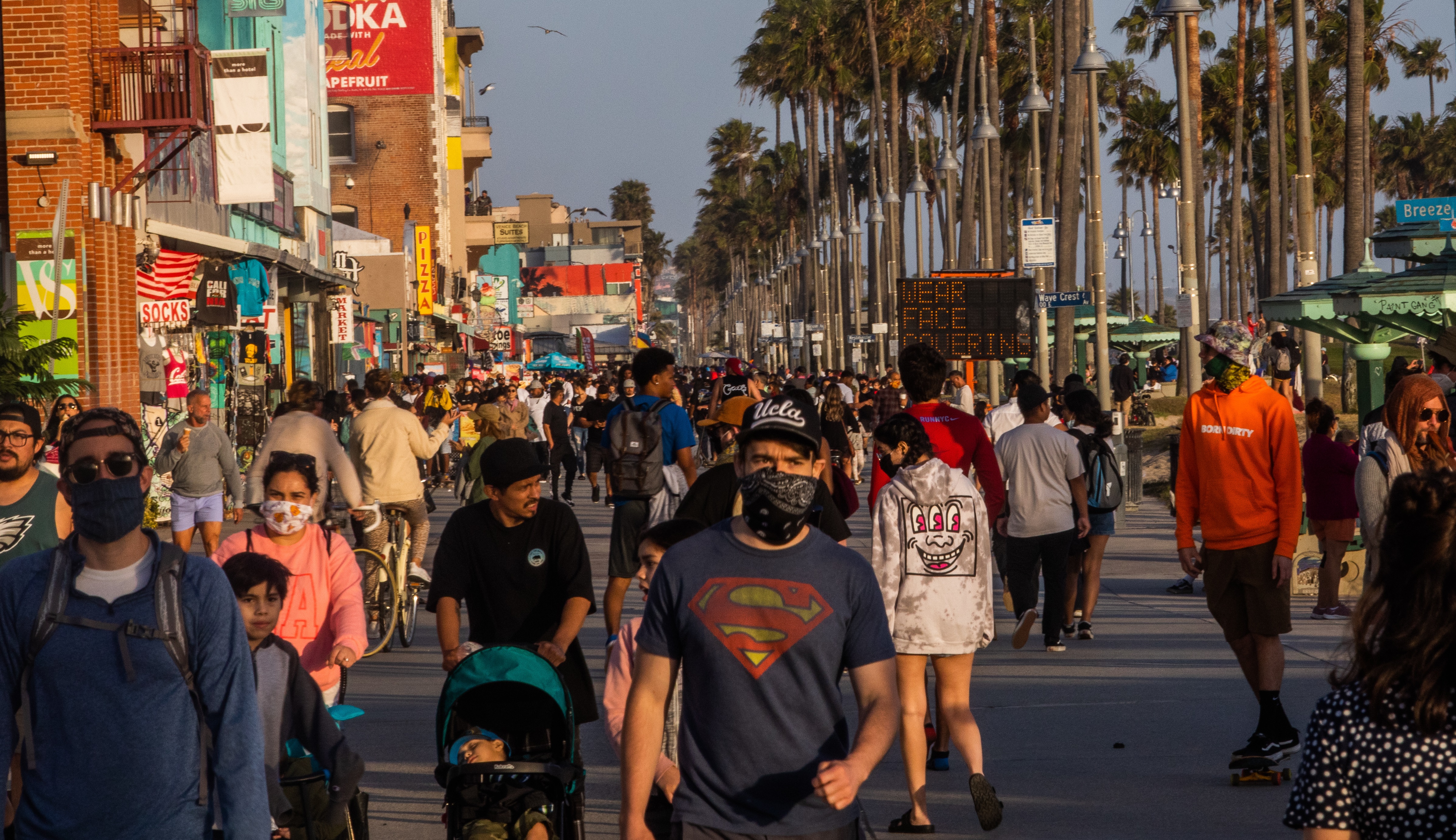 Una multitud en Venice Beach, algunos con mascarillas