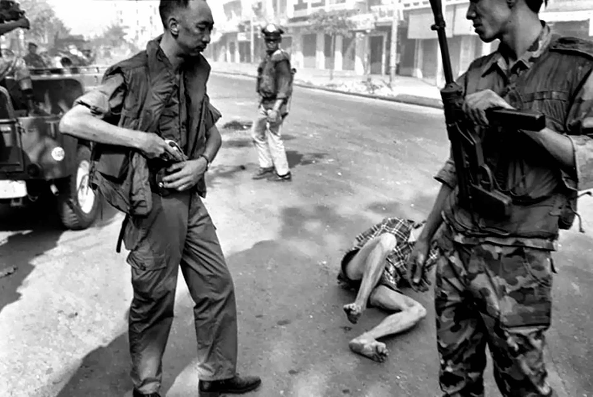 El general de Vietnam del Sur Nguyen Ngoc Loan, jefe de la policía nacional, enfunda su arma después de ejecutar al oficial del Vietcong Nguyen Van Lem, cuyo cuerpo yace en una calle de Saigón, el 1 de febrero de 1968, al comienzo de la Ofensiva del Tet (Foto AP/Eddie Adams)
