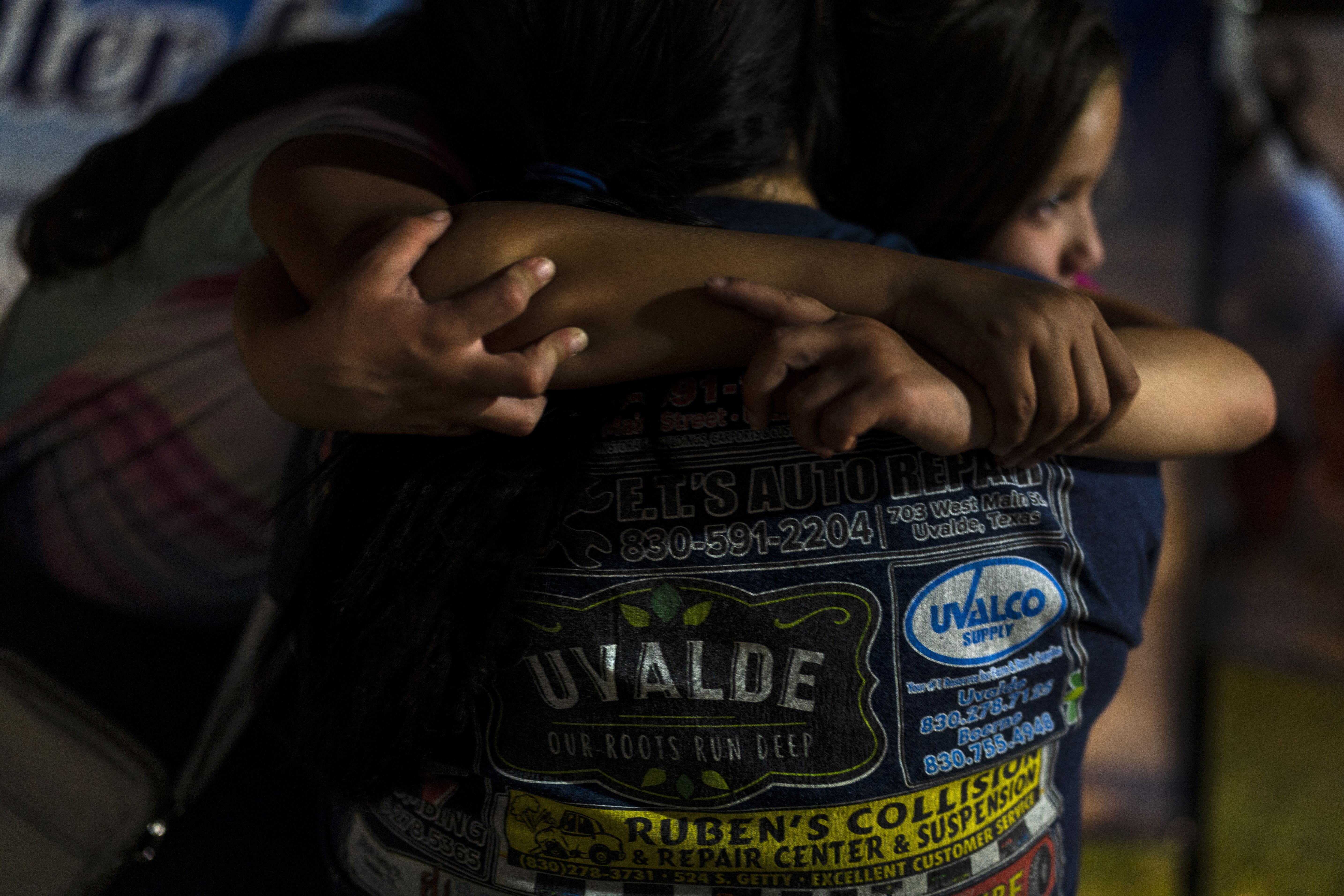 Una madre y sus dos hijas se abrazan el 31 de mayo de 2022 en una plaza de la ciudad mientras visitan un sitio en memoria a las víctimas asesinadas la semana anterior en un tiroteo en la escuela primaria de Uvalde, Texas (AP Foto/Jae C. Hong)