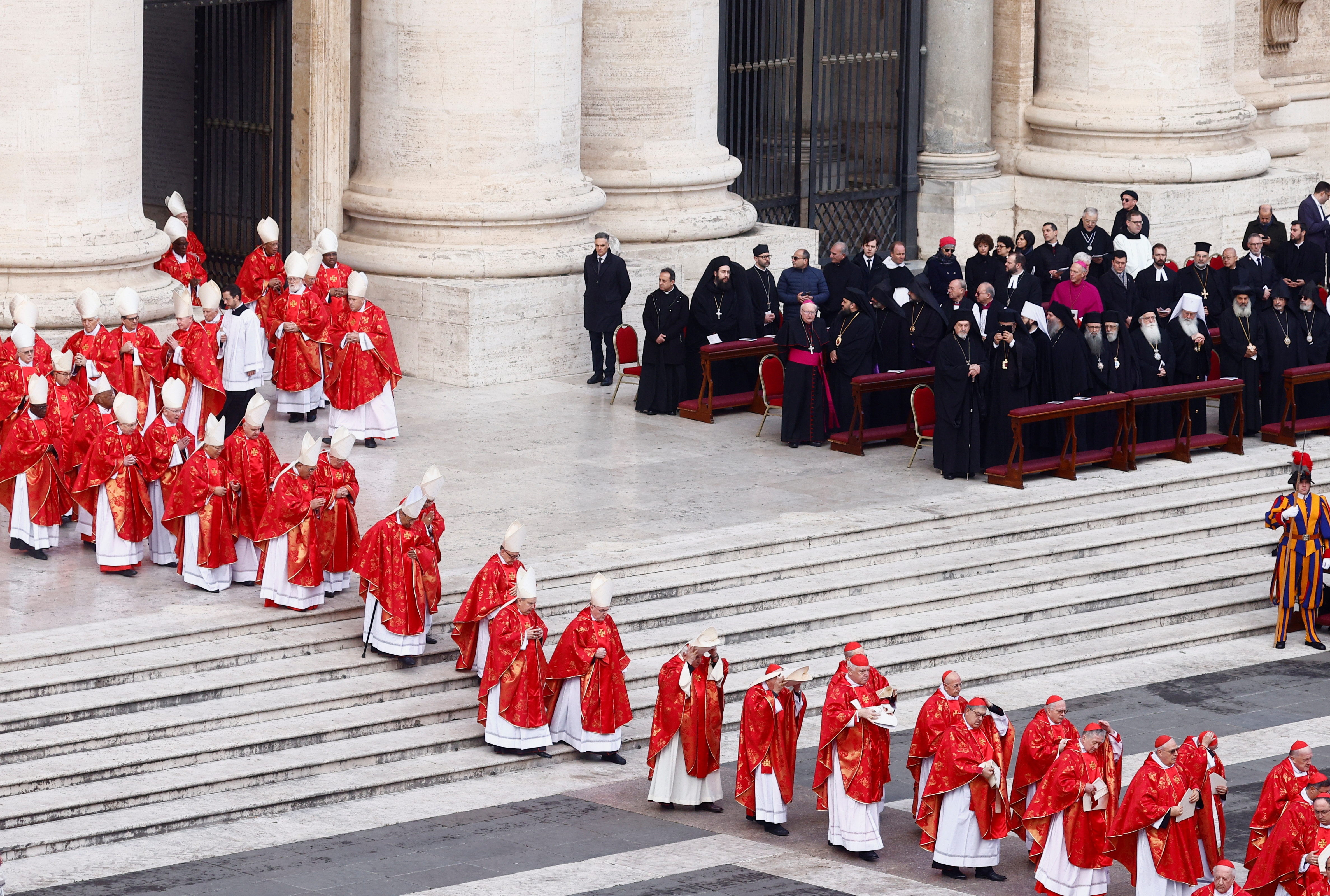 Los cardenales entran en una fila para asistir a la ceremonia en conmemoración de Benedicto XVI.