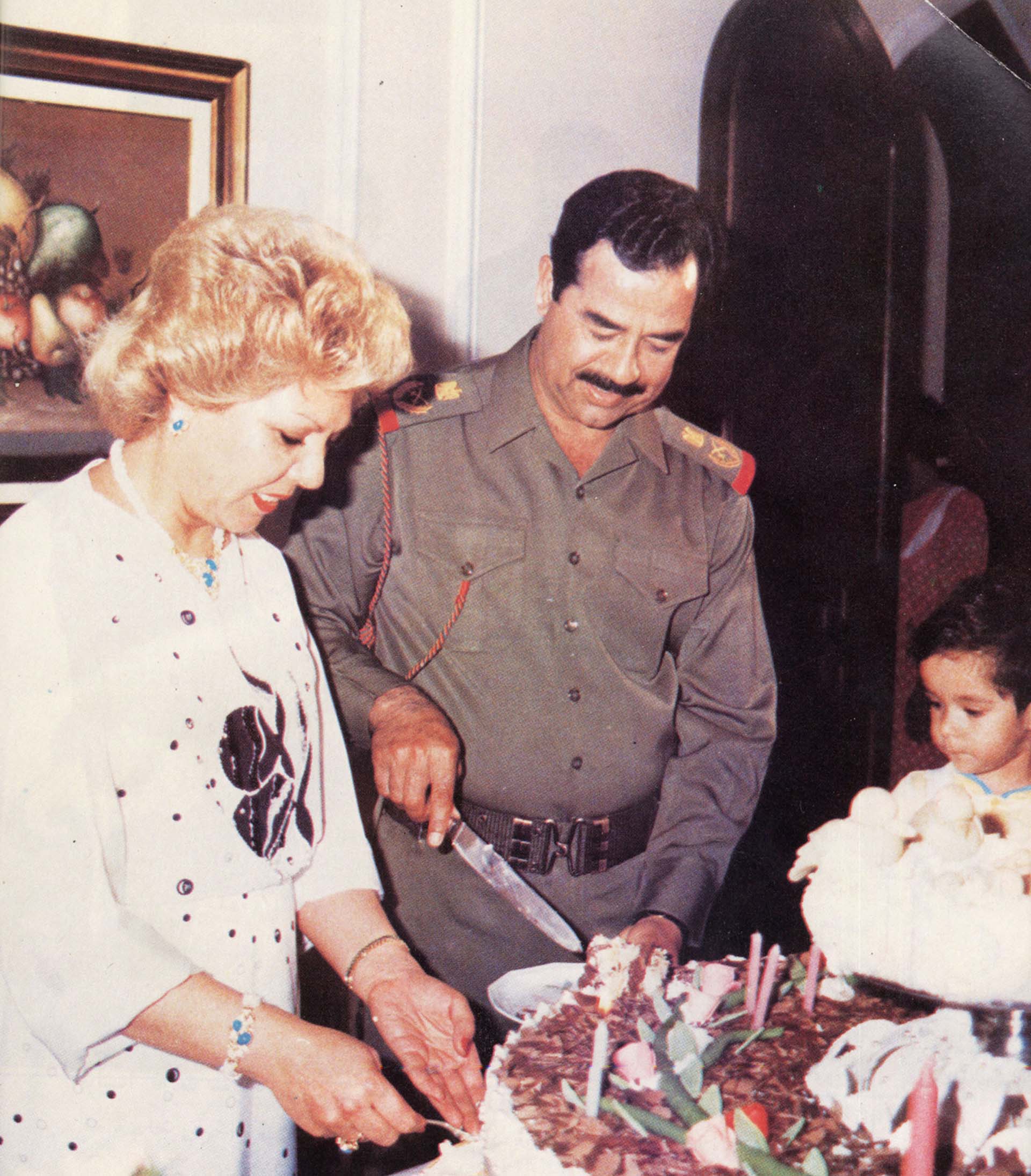 La intimidad de Saddam Hussein: el tirano corta un pedazo de torta junto a su esposa Sajida y su hija Hala (Getty Images)