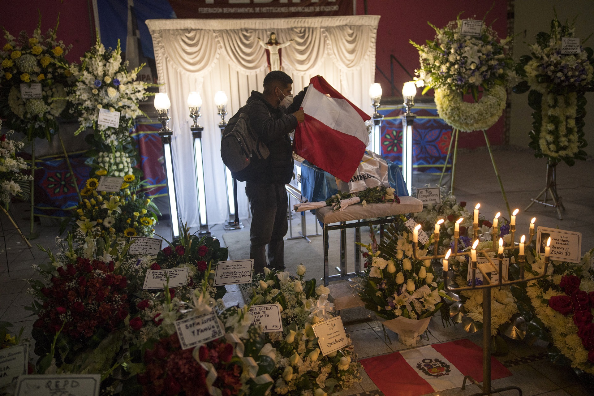 Un joven coloca una bandera sobre el ataúd de Inti Sotelo Camargo en su velorio en Lima (AP Photo/Rodrigo Abd)