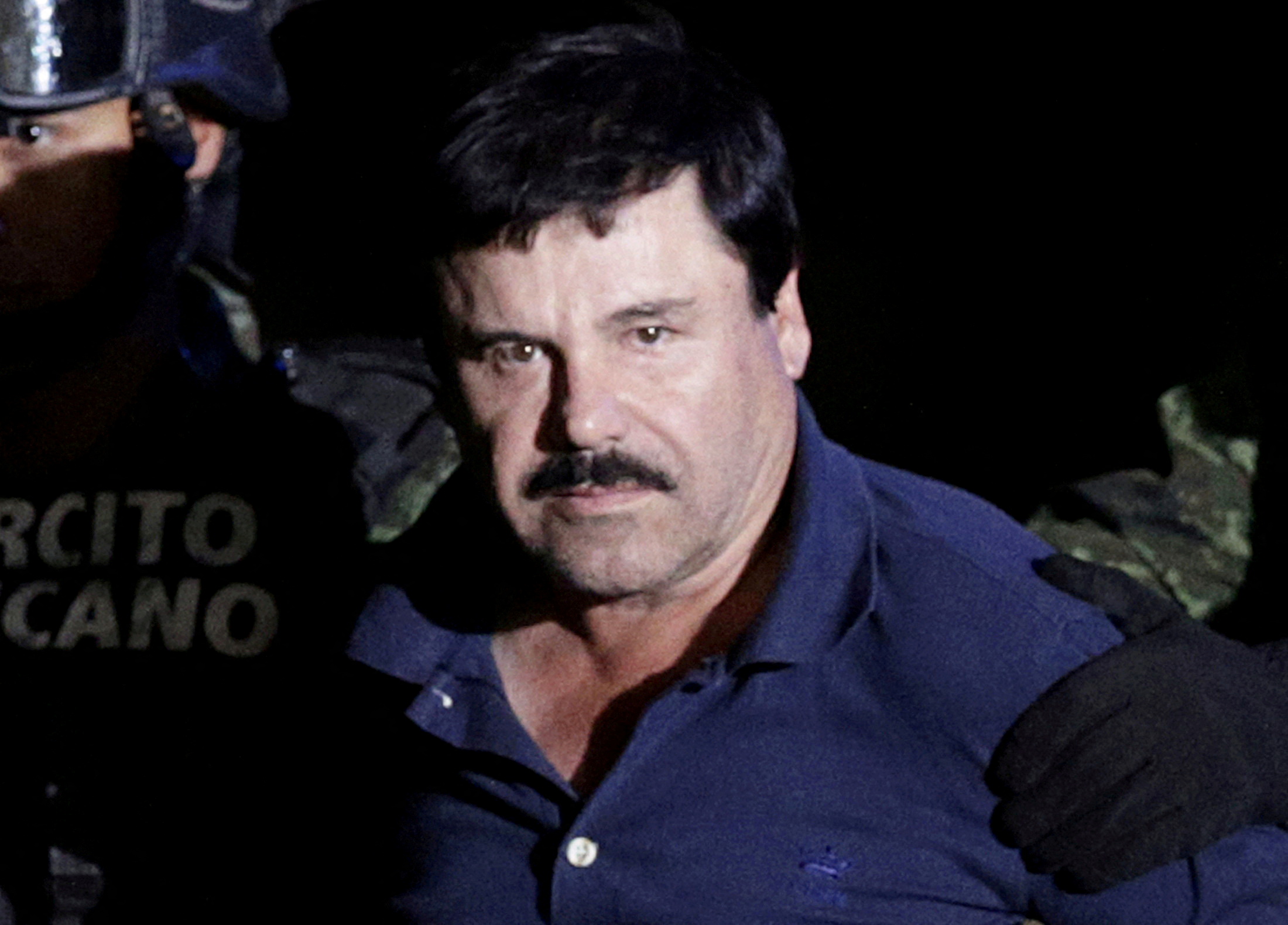 FILE PHOTO: FILE PHOTO: Recaptured drug lord Joaquin "El Chapo" Guzman is escorted by soldiers at the hangar belonging to the office of the Attorney General in Mexico City, Mexico January 8, 2016. REUTERS/Henry Romero/File Photo/File Photo/File Photo