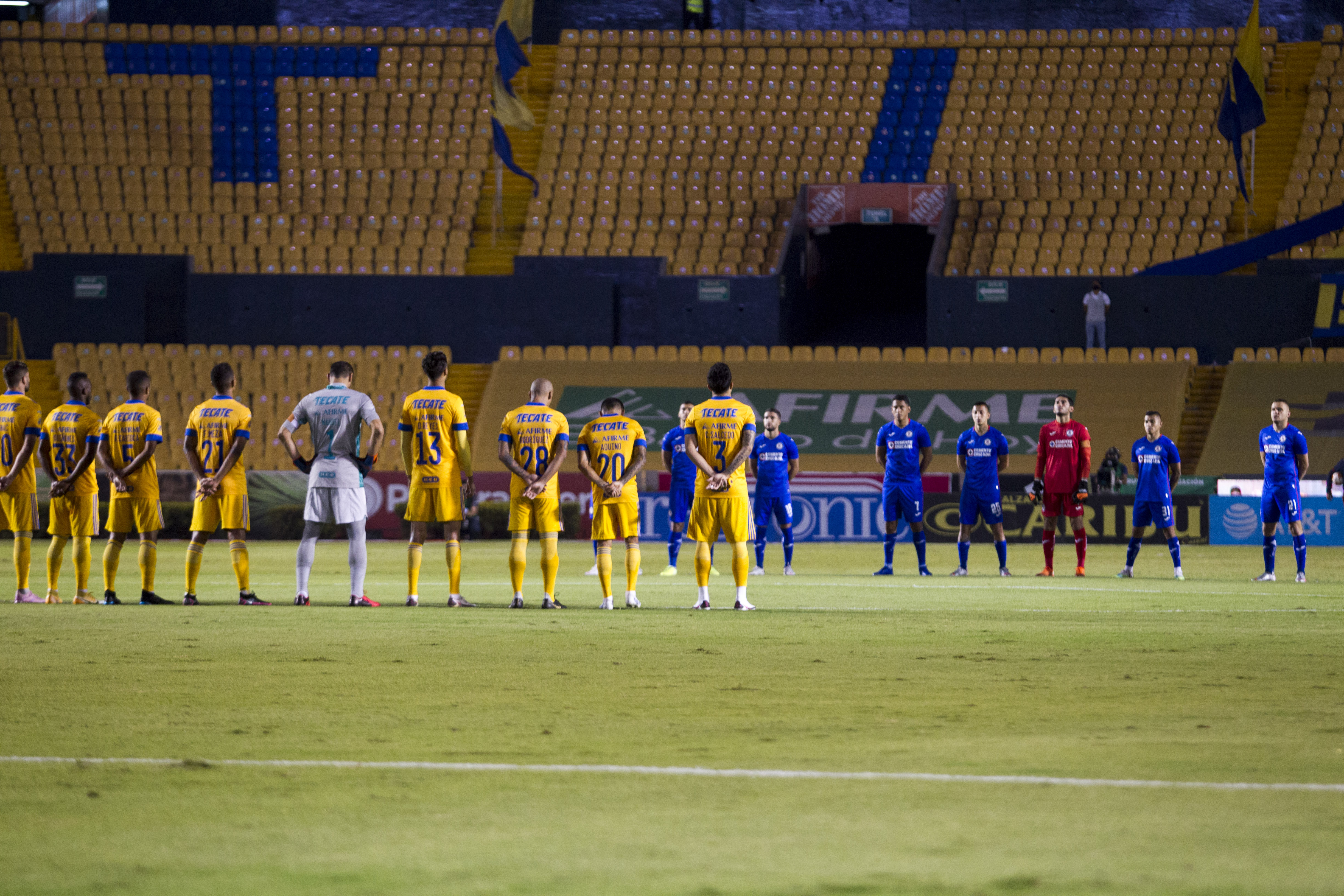 Players of Tigres (L) and Cruz Azul (R) pay a minute of silence in homage to late Argentine football star Diego Armando Maradona, a day after his passing, before their first leg quarterfinal football match of the Mexican Apertura 2020 tournament at the Universitario stadium in Monterrey, Mexico, on November 26, 2020, amid the COVID-19 coronavirus pandemic. (Photo by Julio Cesar AGUILAR / AFP)