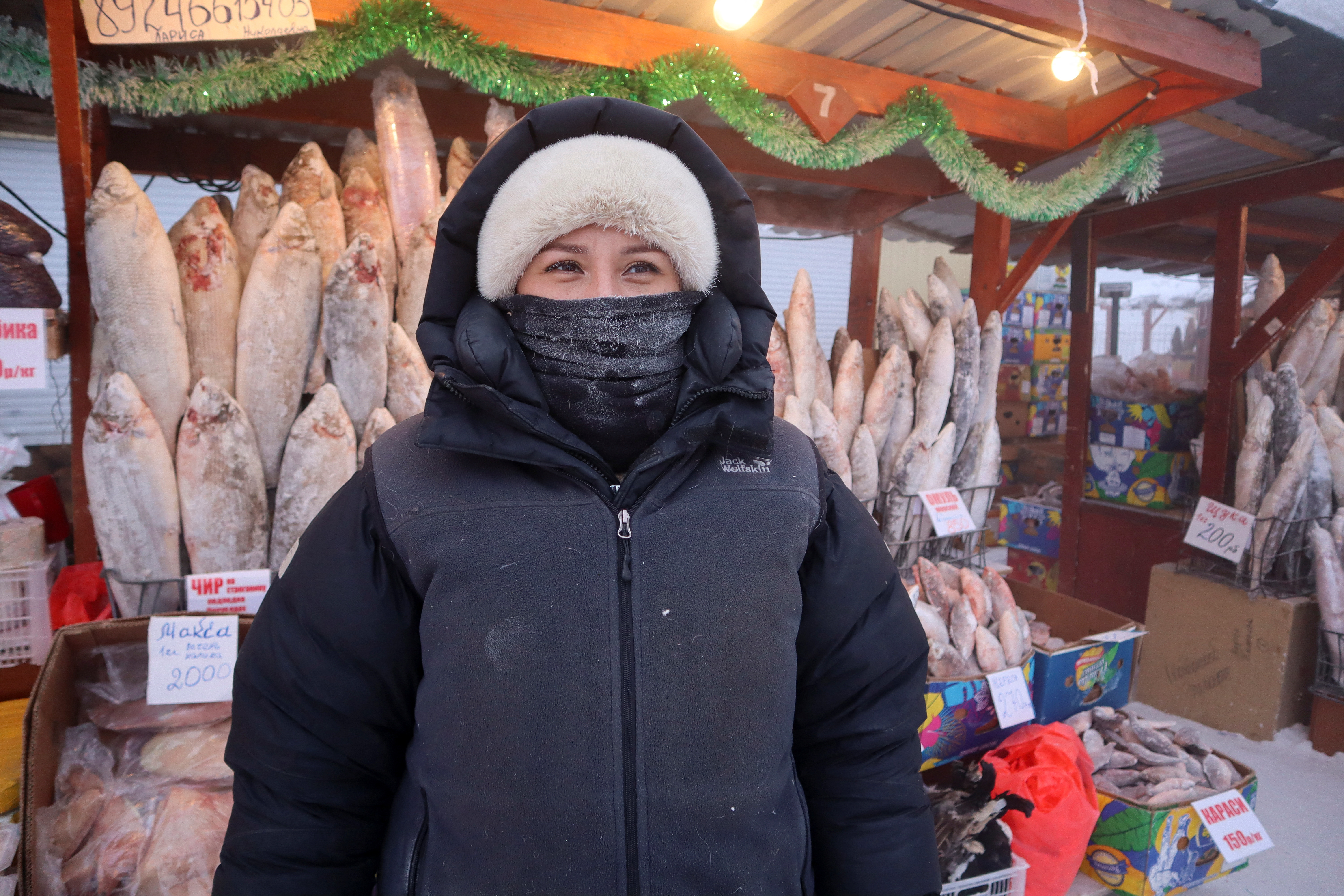 La vendedora de pescado Alyona Zaitseva posa para una foto en un mercado al aire libre en un día helado en Yakutsk, Rusia, este 15 de enero de 2023 (Reuters)