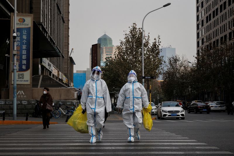 FOTO DE ARCHIVO. Trabajadores de prevención con trajes protectores cruzan una calle mientras continúan los brotes de la enfermedad por coronavirus (COVID-19) en Beijing, China. 9 de diciembre de 2022. REUTERS/Thomas Peter