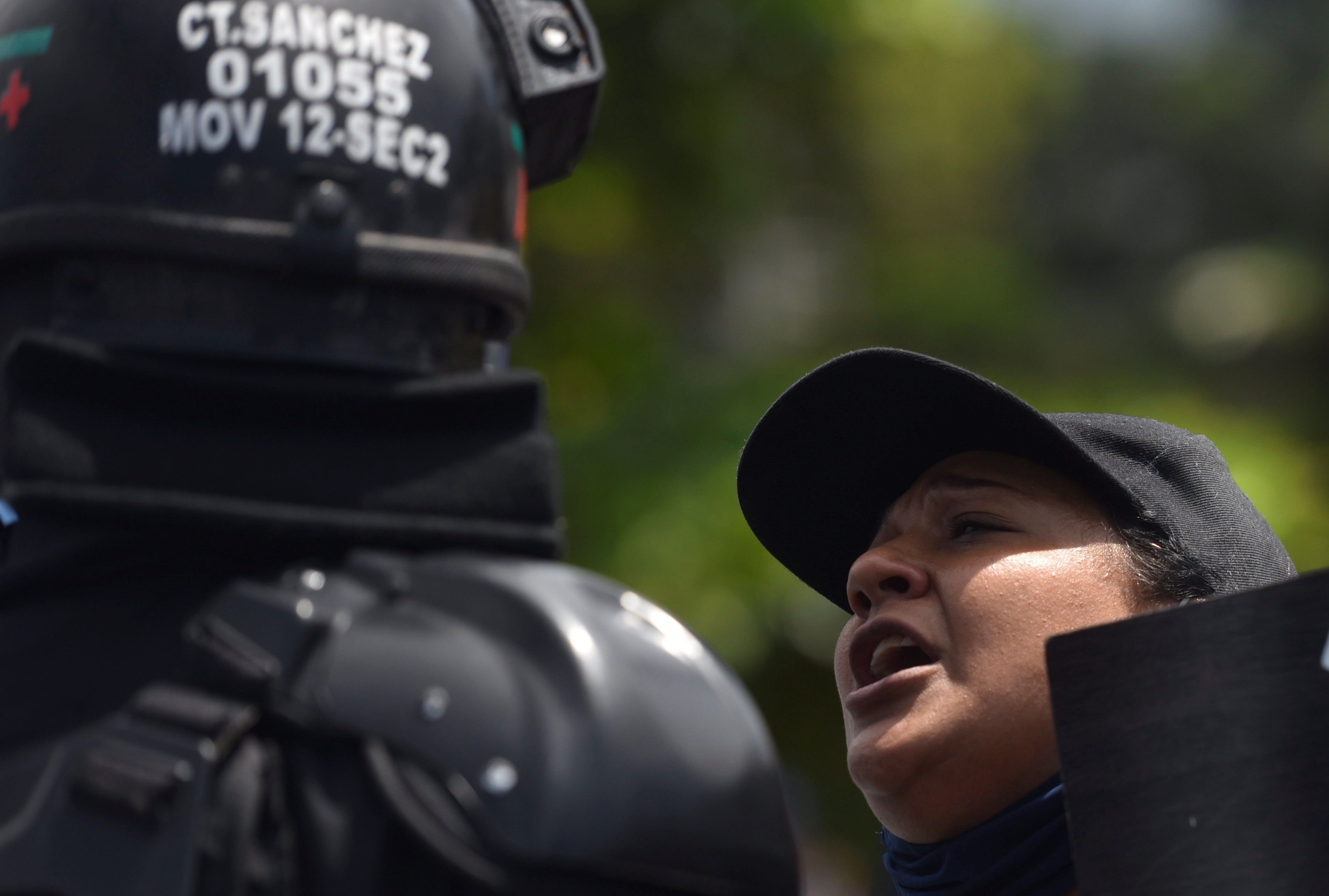 Una mujer discute con un policía del Escuadrón Móvil Antidisturbios (ESMAD) mientras vigilan la vía "Paso del Comercio", este viernes 4 de junio de 2021, en Cali (Colombia). EFE/Ernesto Guzmán Jr.
